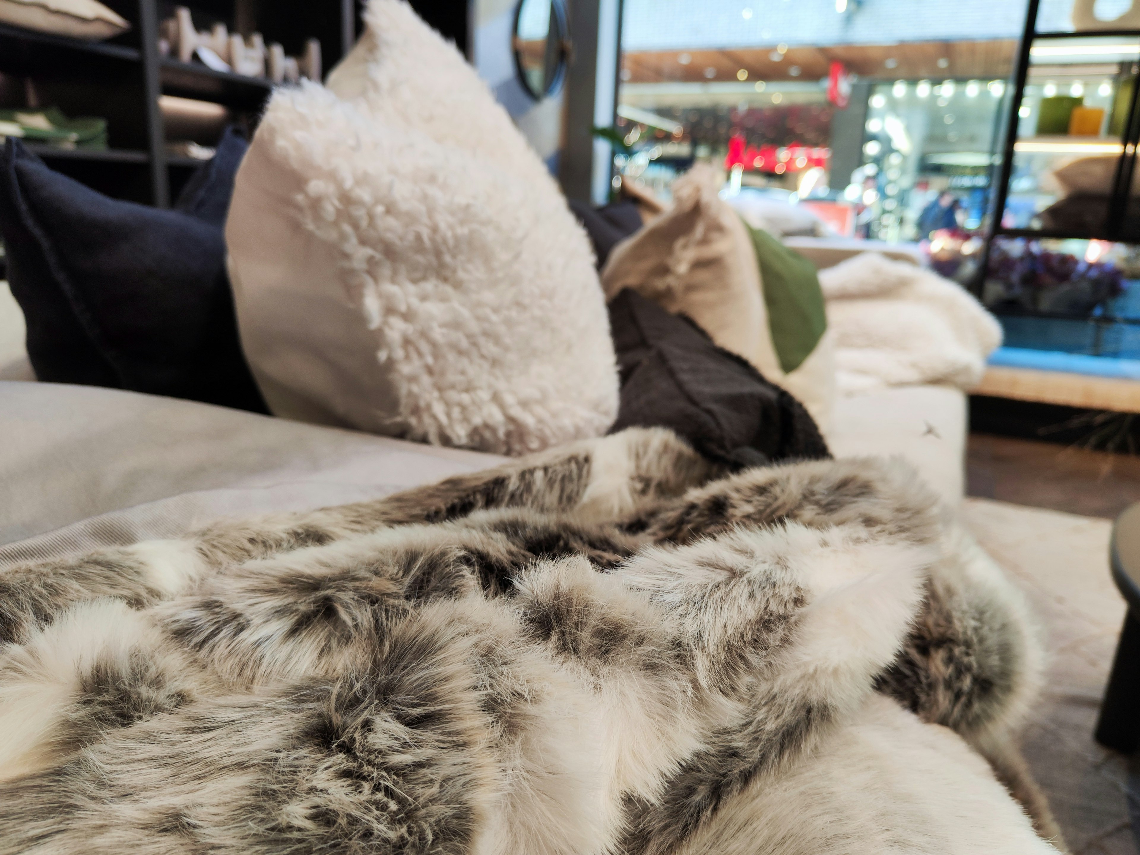 Close-up of a soft blanket and cushions on a sofa