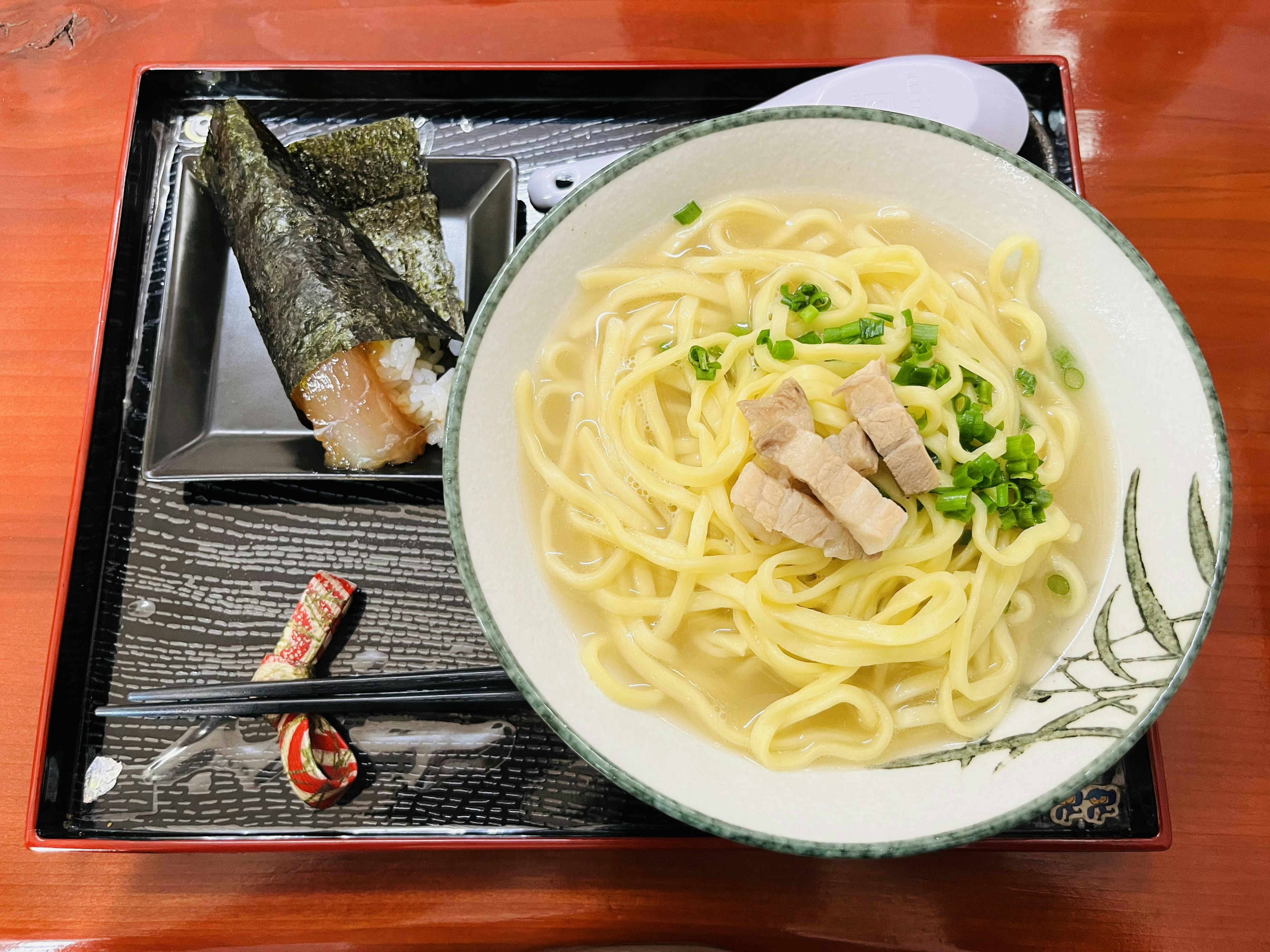 白い皿に盛られた温かいラーメンと鶏肉のスライス 緑のネギがトッピングされた料理