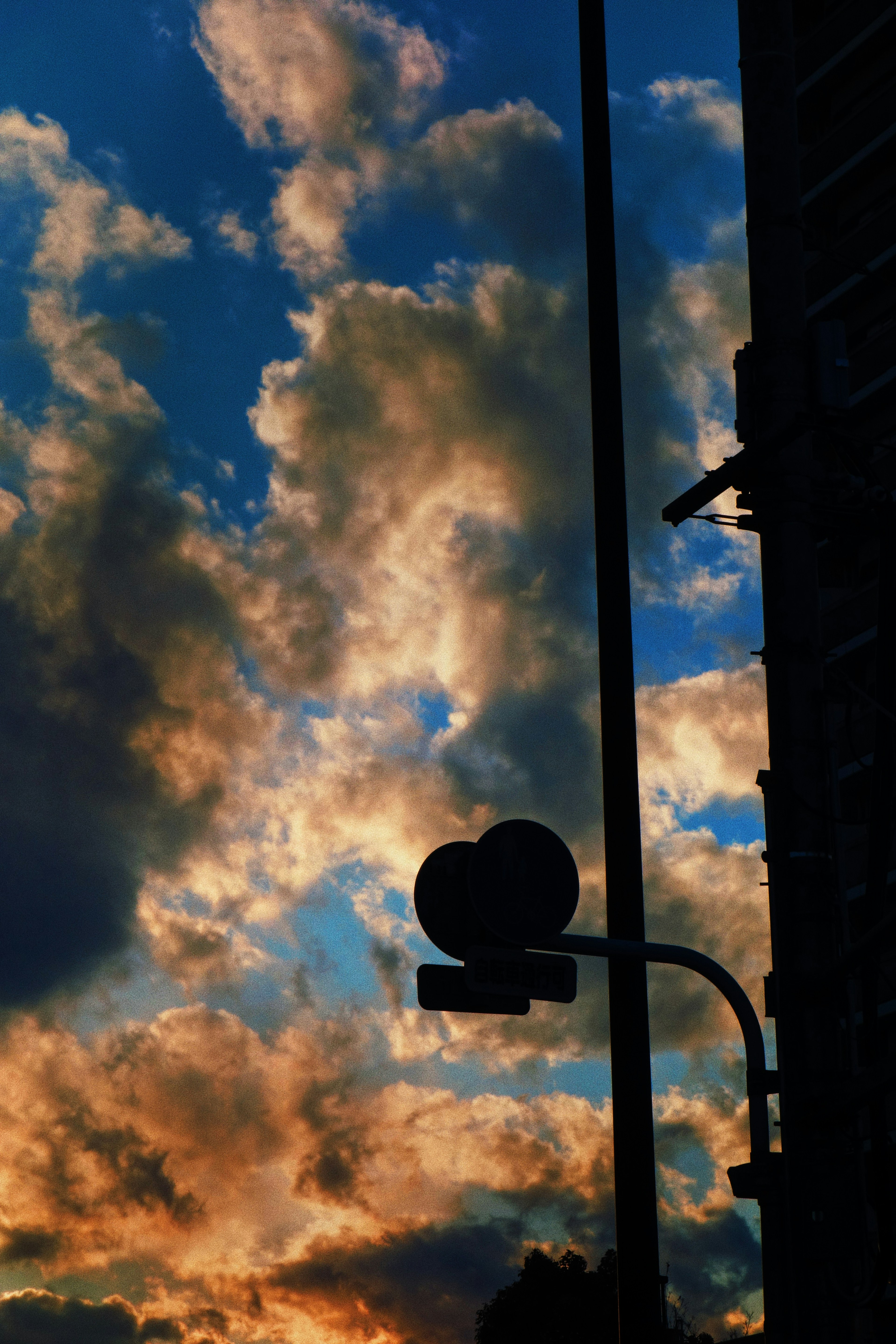 Silhouette of a heart-shaped sign against a colorful sunset sky