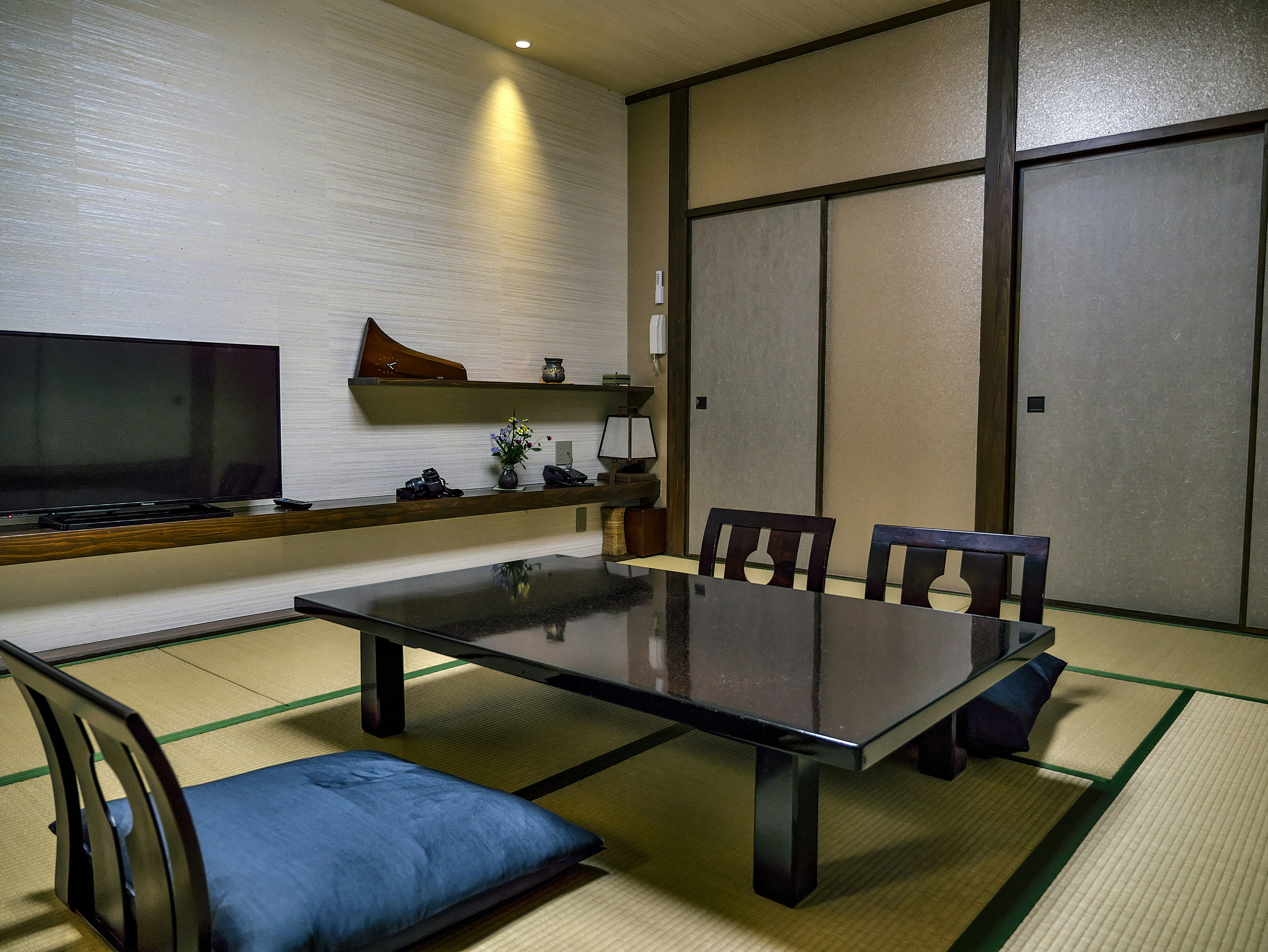 Chambre de style japonais moderne avec une table noire et des coussins