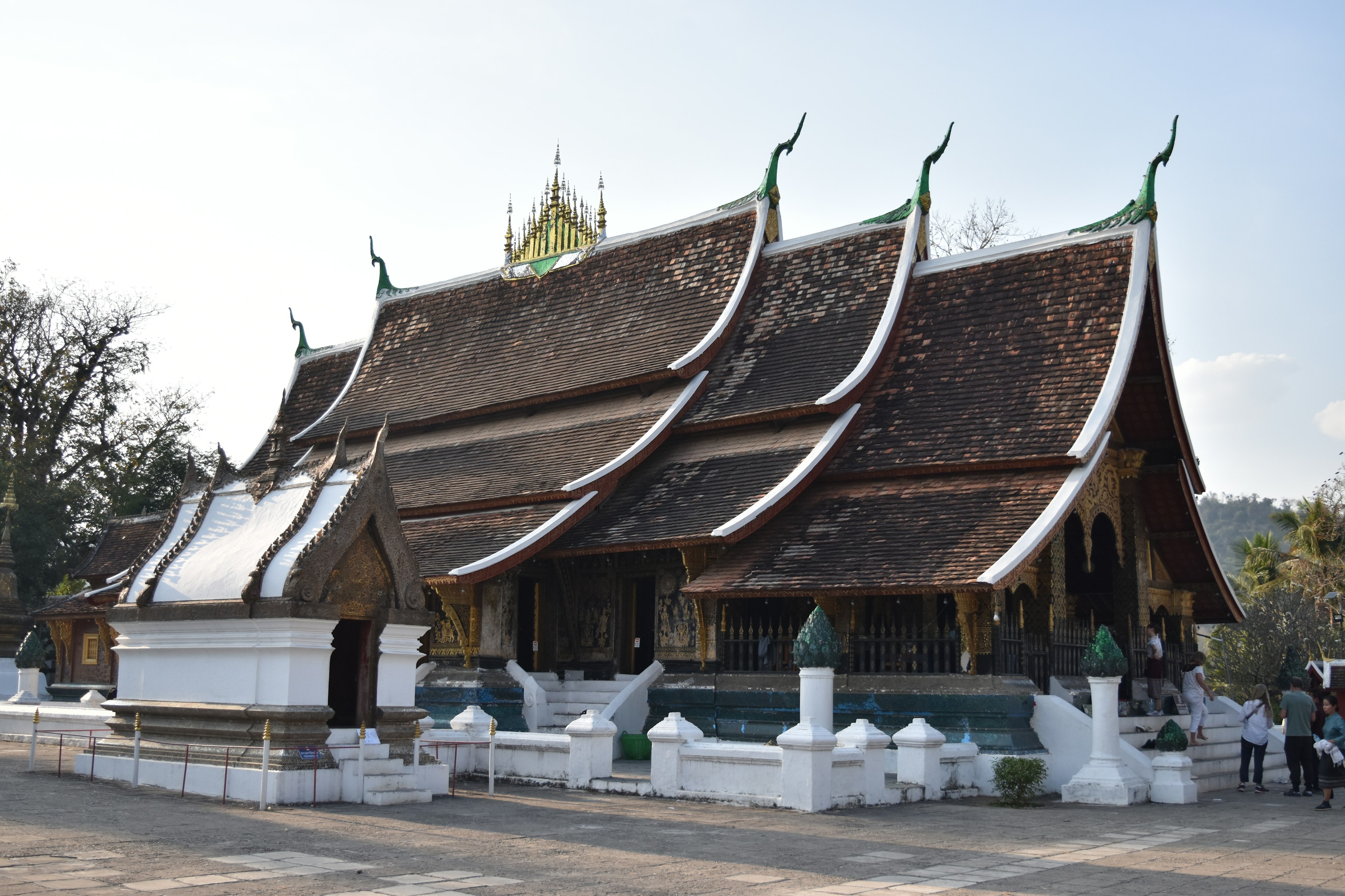 Tampilan luar sebuah kuil indah di Laos dengan desain atap yang unik