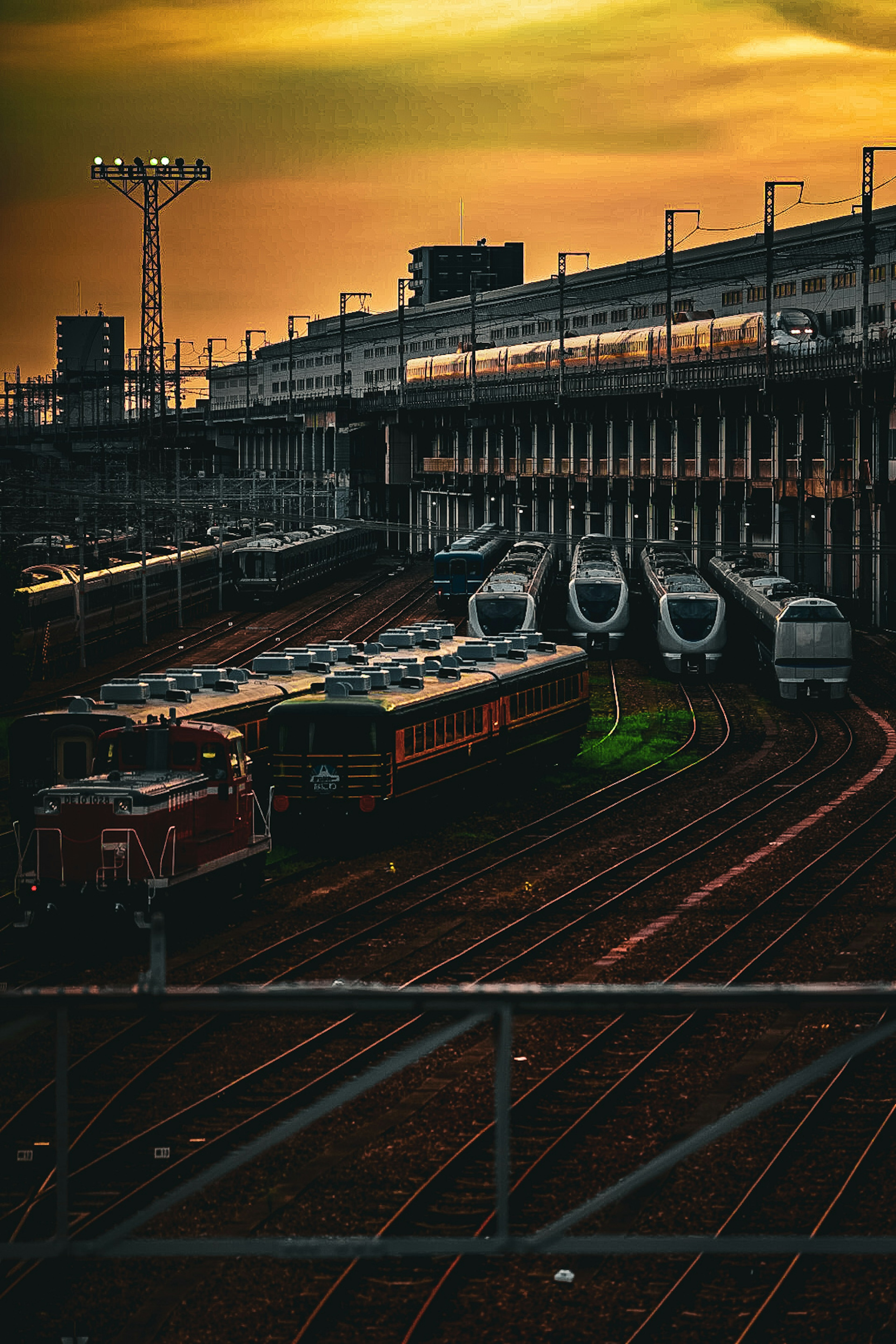 日落時的火車場，有多列火車和軌道