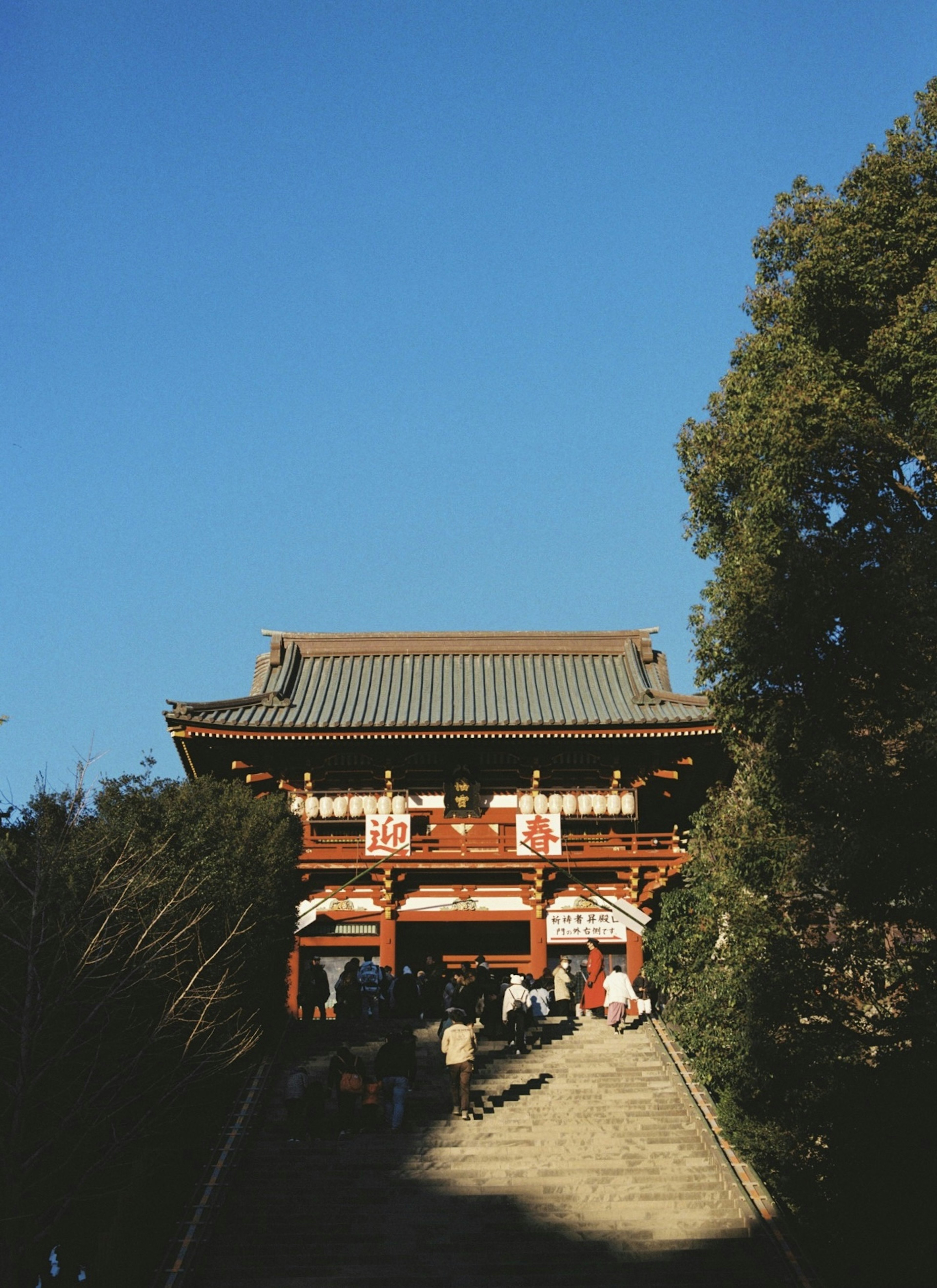 青空の下の伝統的な日本の寺院の入り口と人々