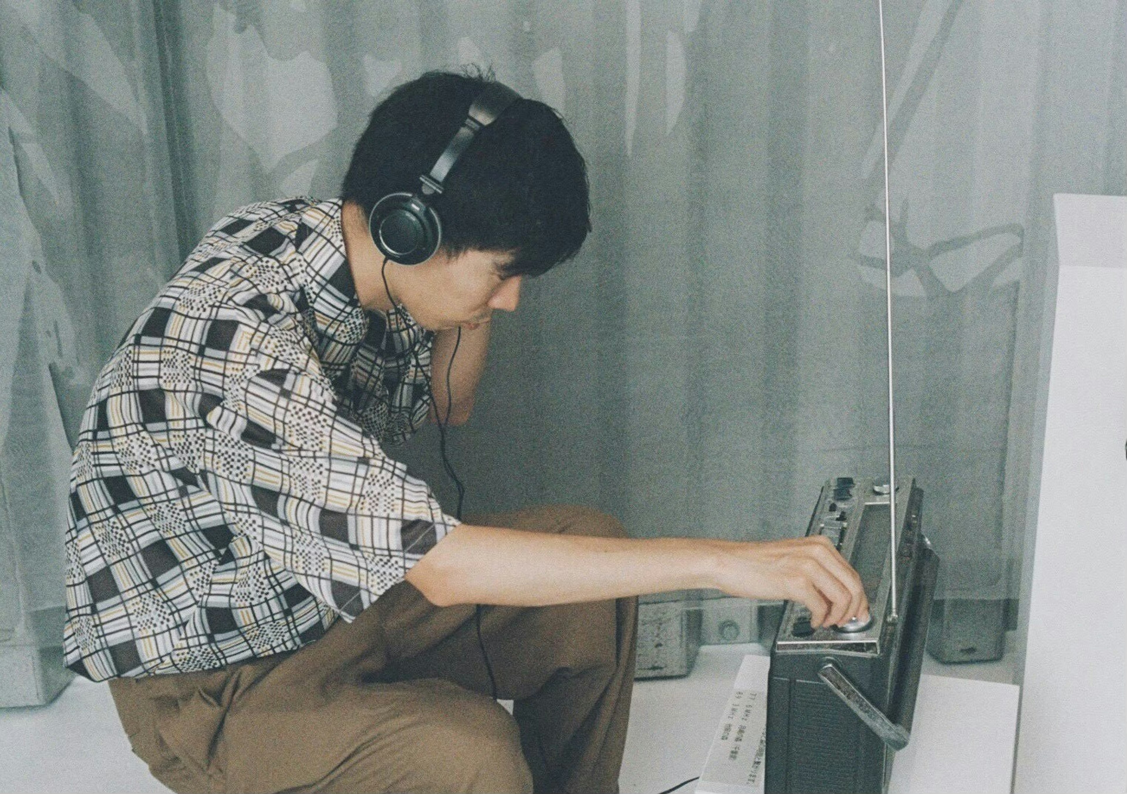 Joven con auriculares ajustando una radio