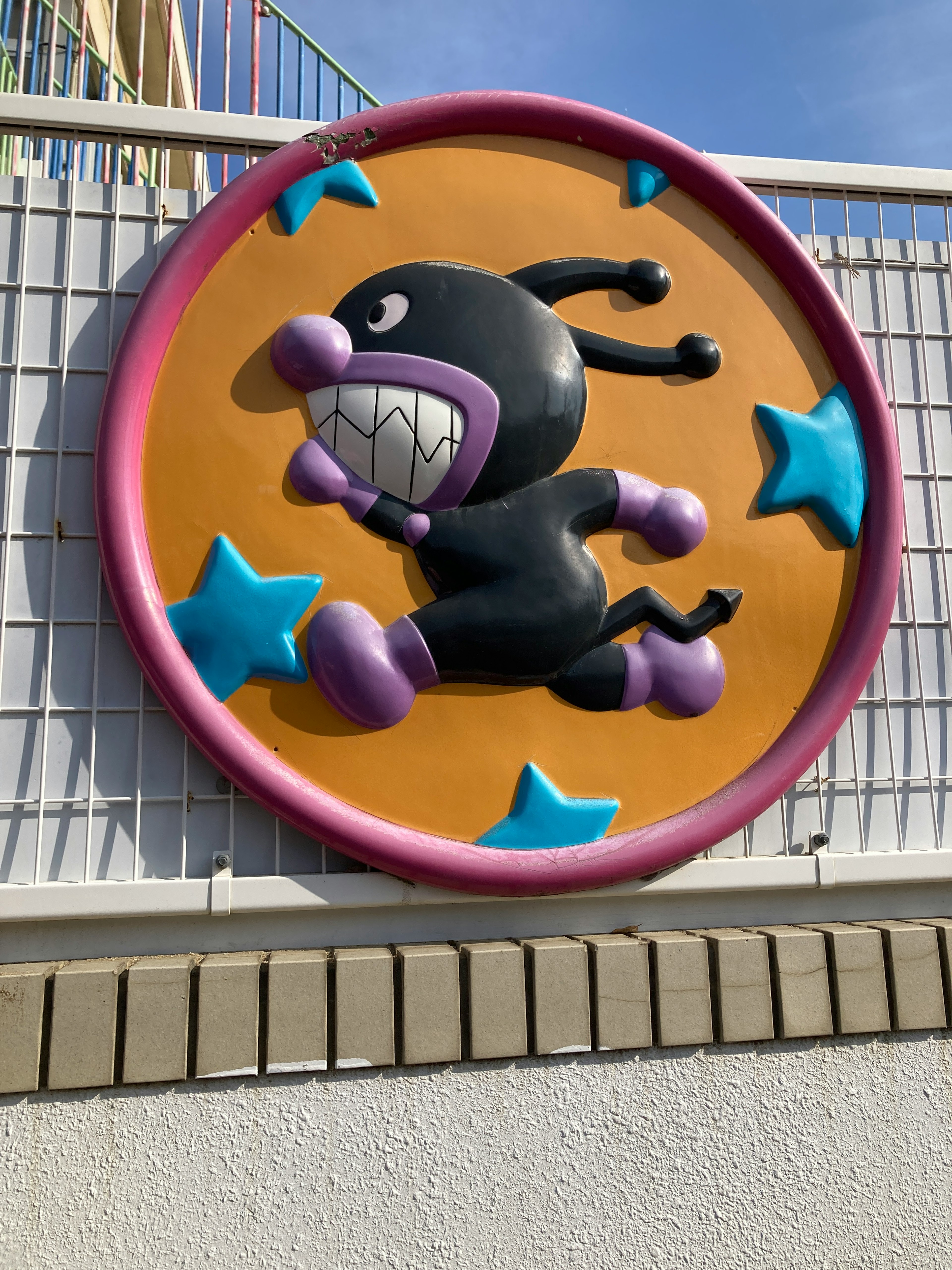 A black character running around blue stars on a three-dimensional sign