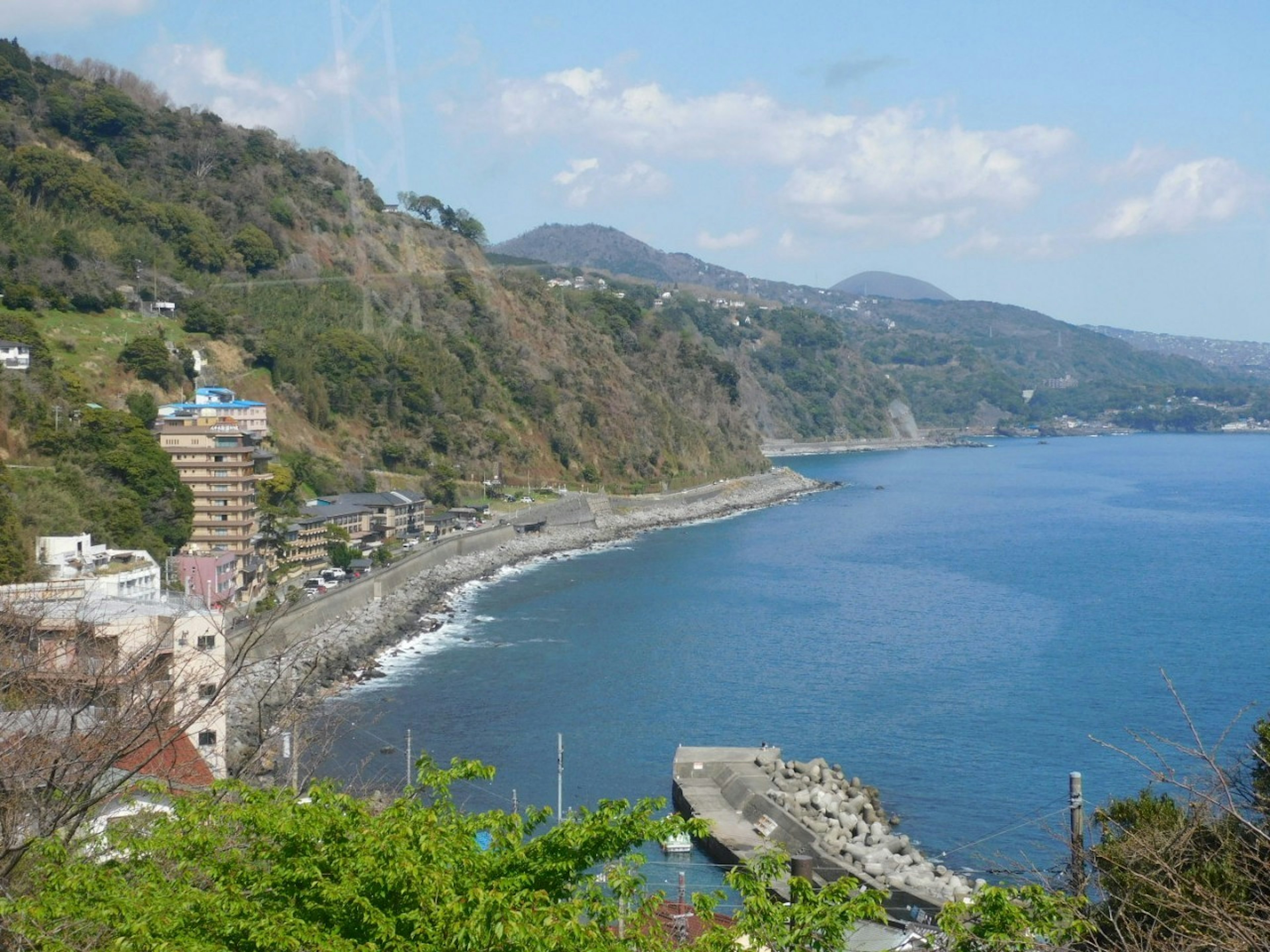 Vista de una ciudad costera con montañas y océano de fondo