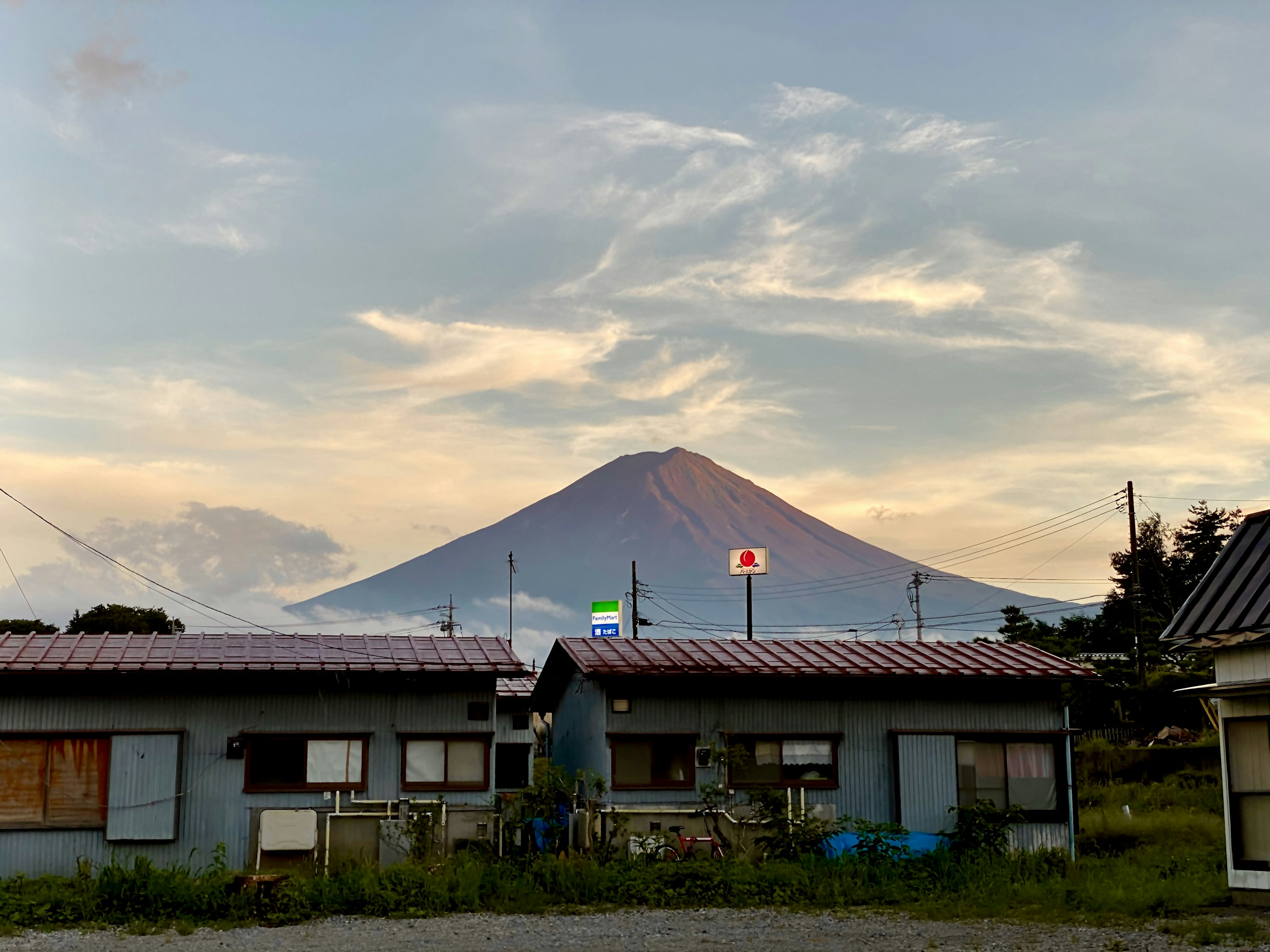 Houses with Mount Fuji in the background and a sunset sky