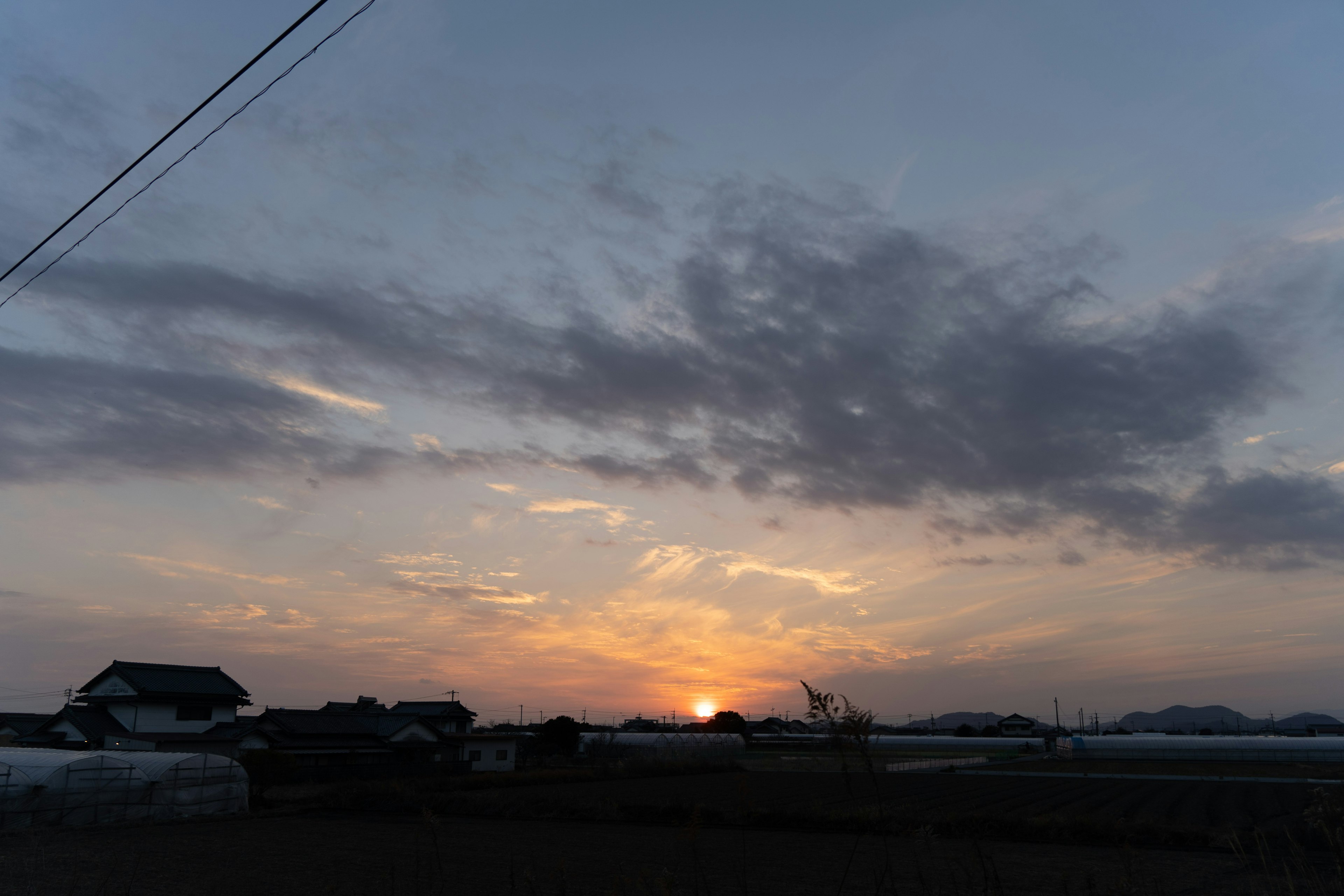 夕暮れの空に広がる雲と沈む太陽の美しい風景