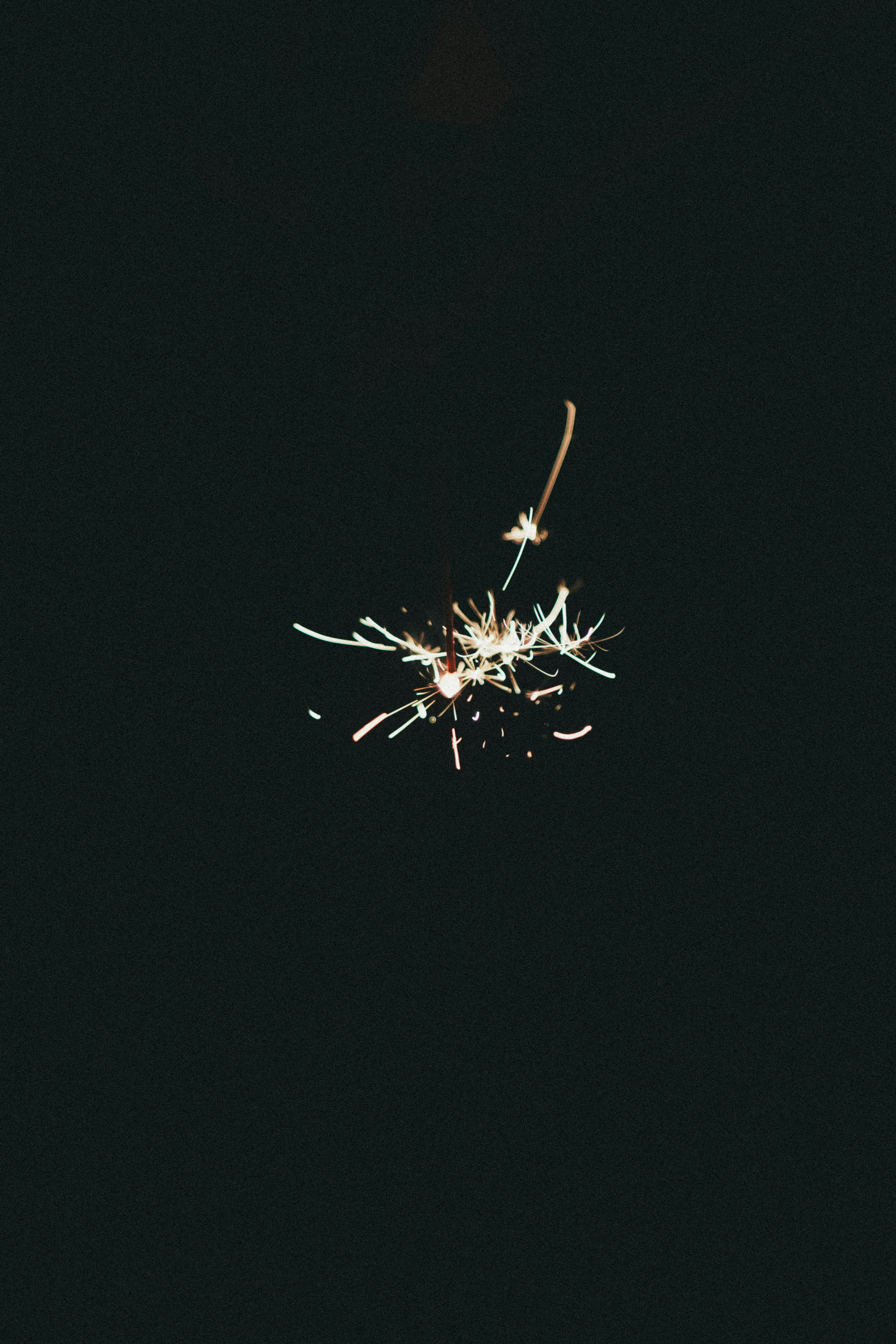 Sparkler glowing against a dark background