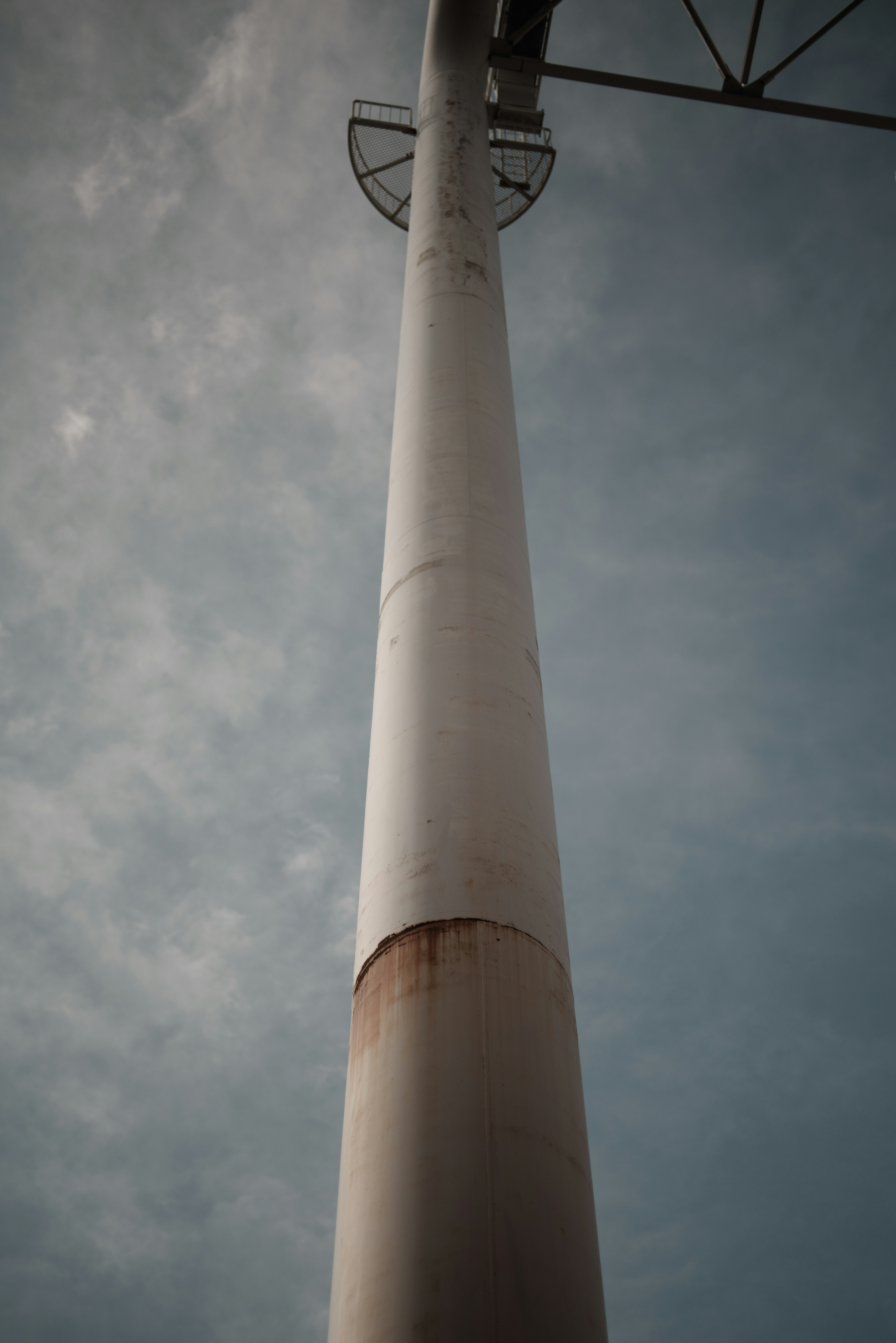 Immagine di una torre di turbina eolica vista dal basso sotto un cielo nuvoloso