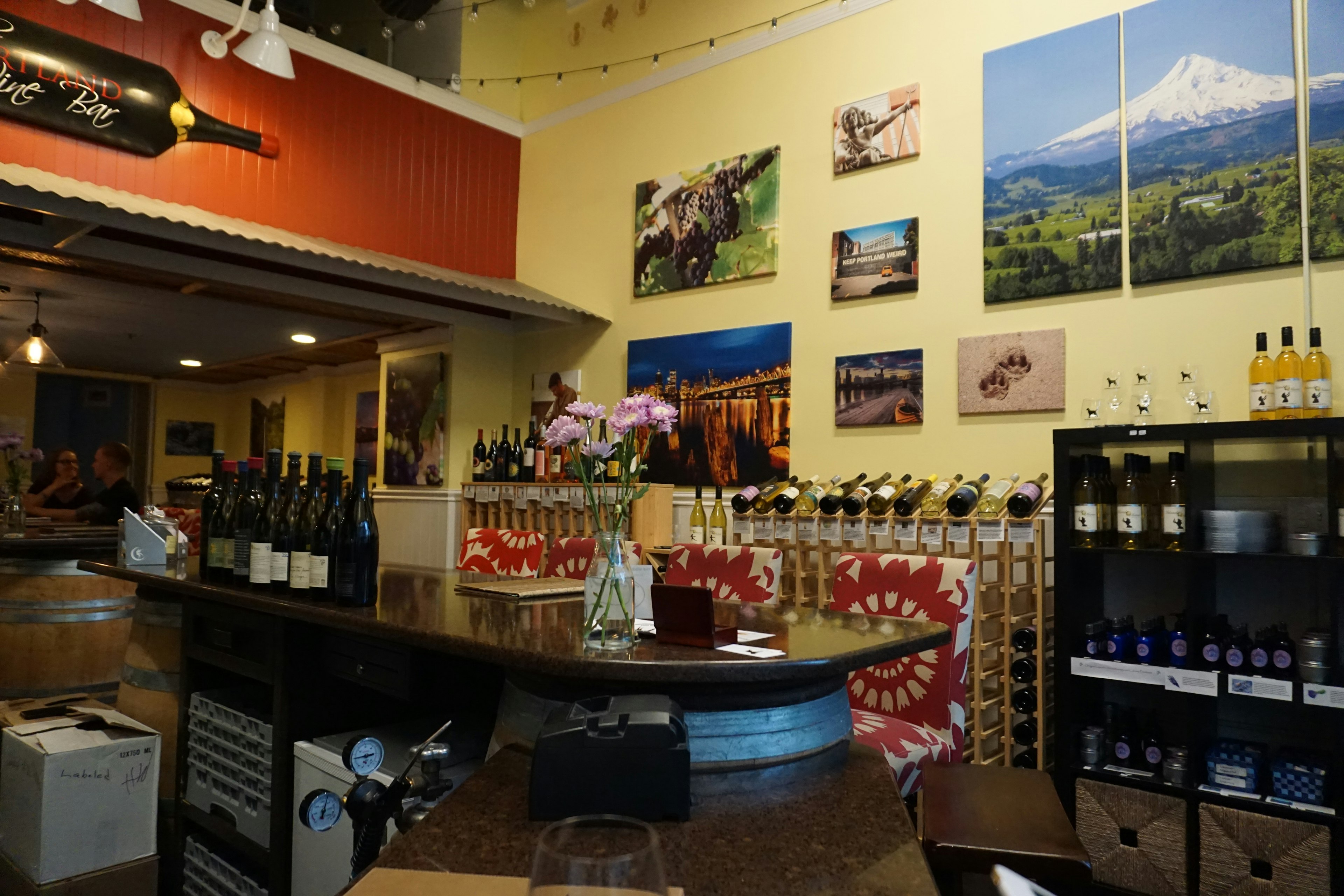 Vista interna di una cantina con un bancone e bottiglie di vino colorate