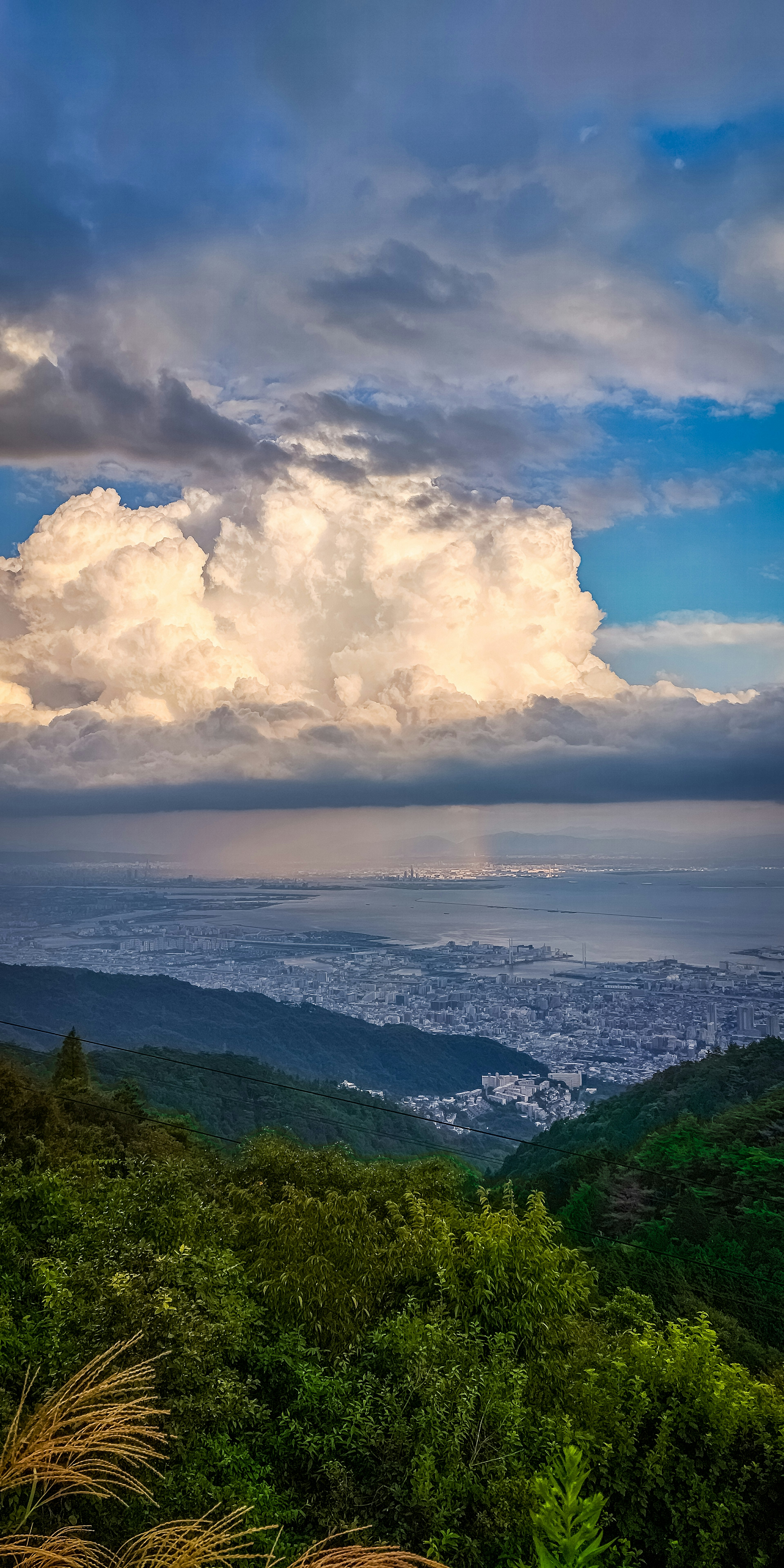 Mountain view overlooking a city by the sea with dramatic clouds