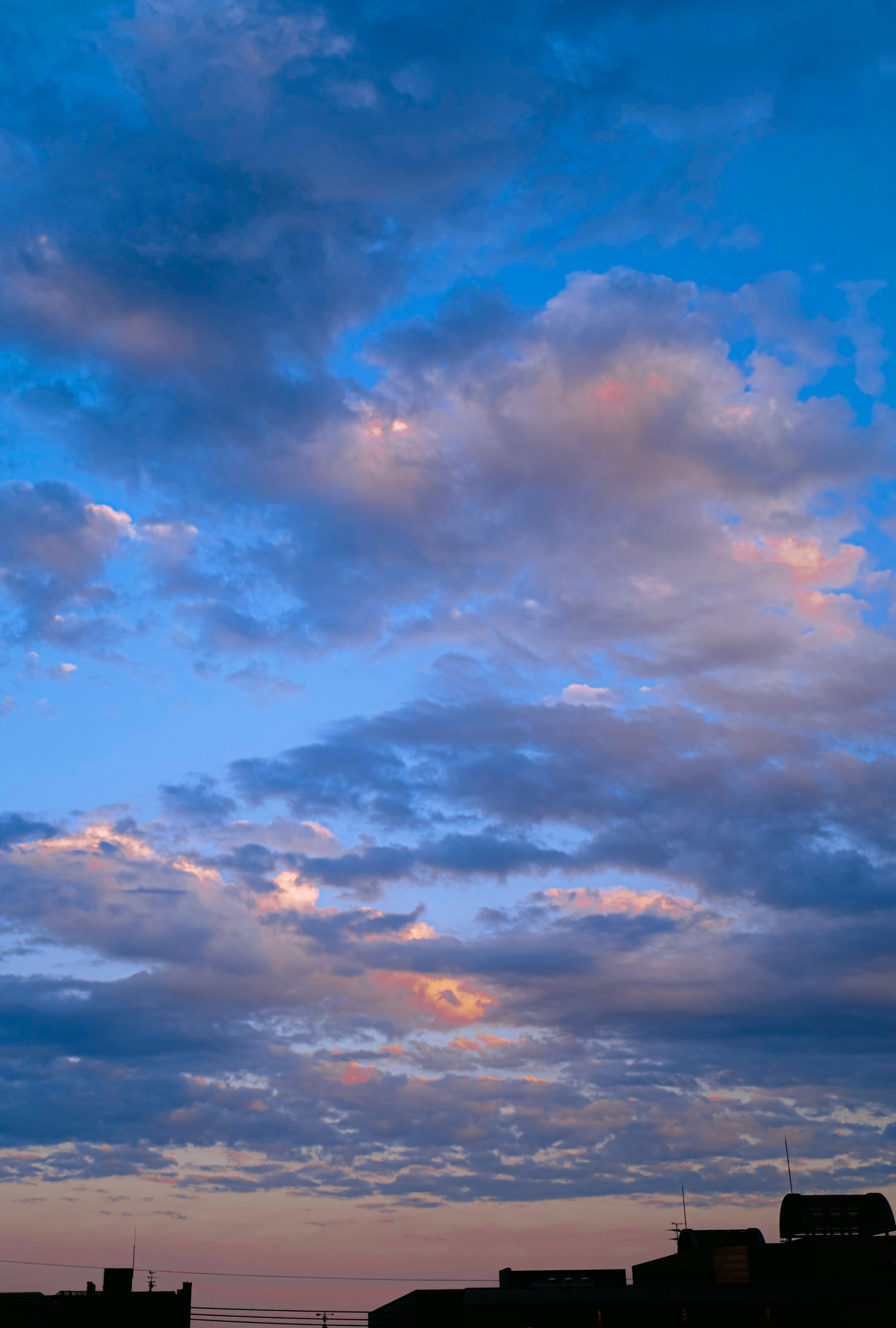 Cielo vibrante al tramonto pieno di nuvole nei toni del blu e del rosa