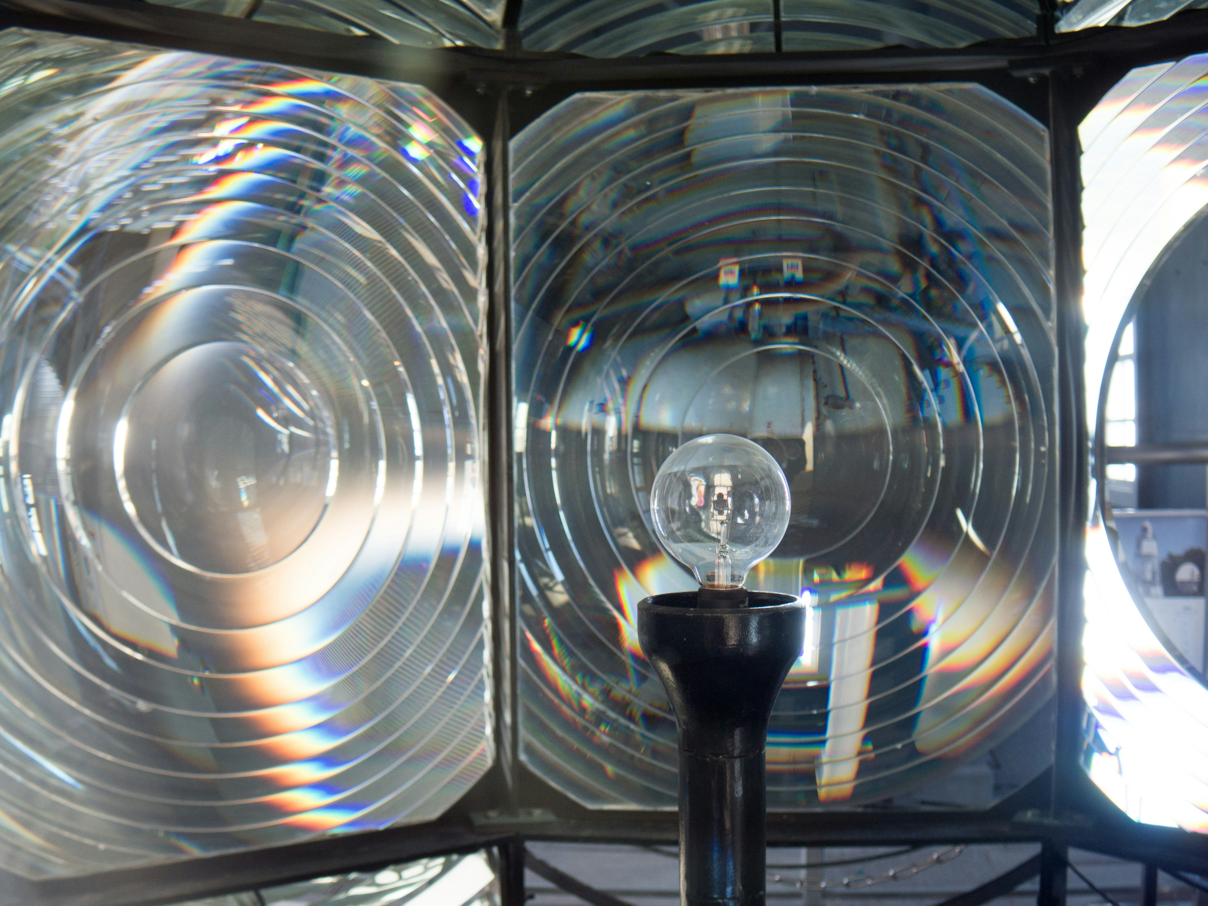 Interior view of a lighthouse lens with a light bulb and reflective panels