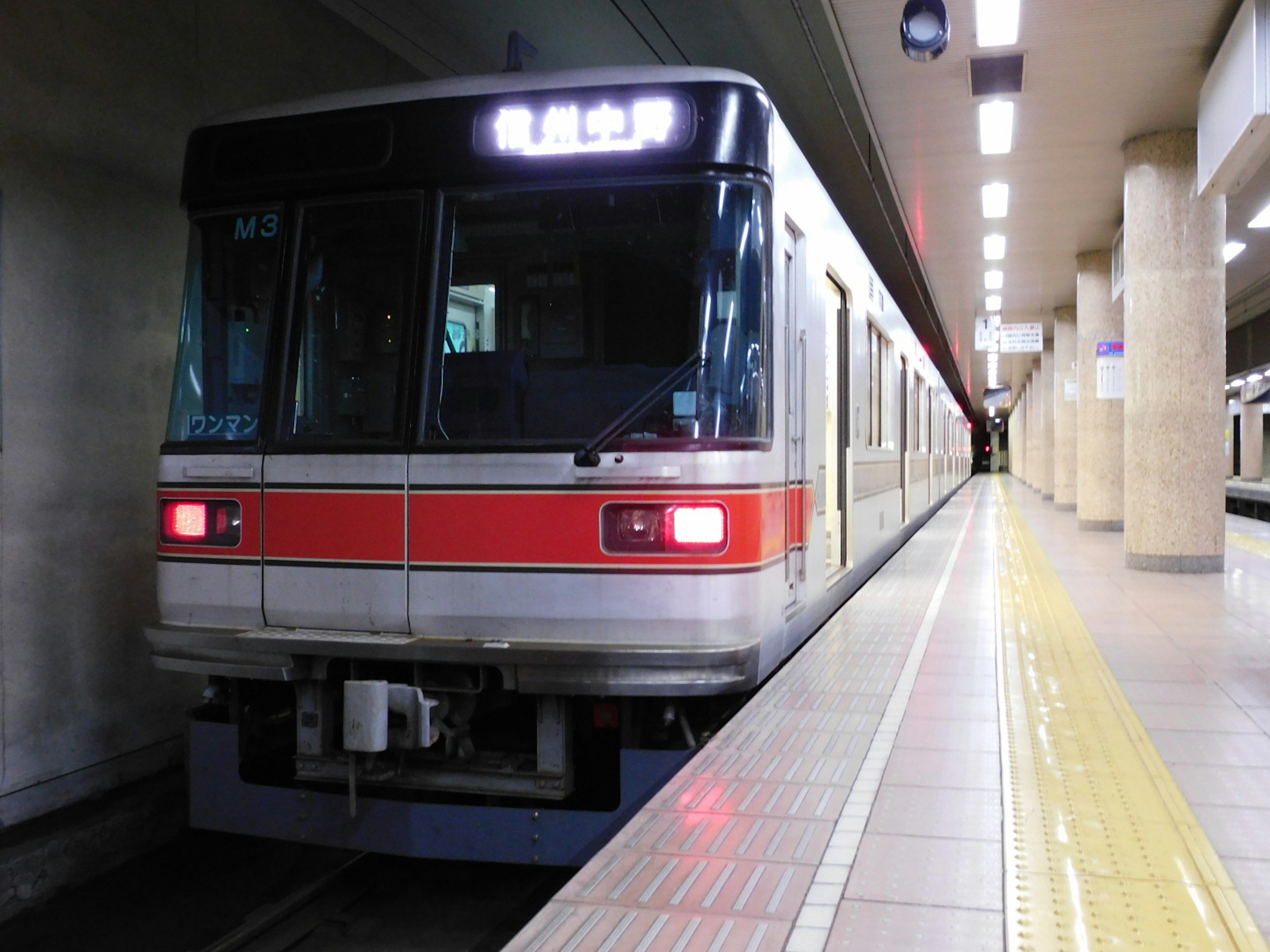 Subway train at a station with a visible front and platform