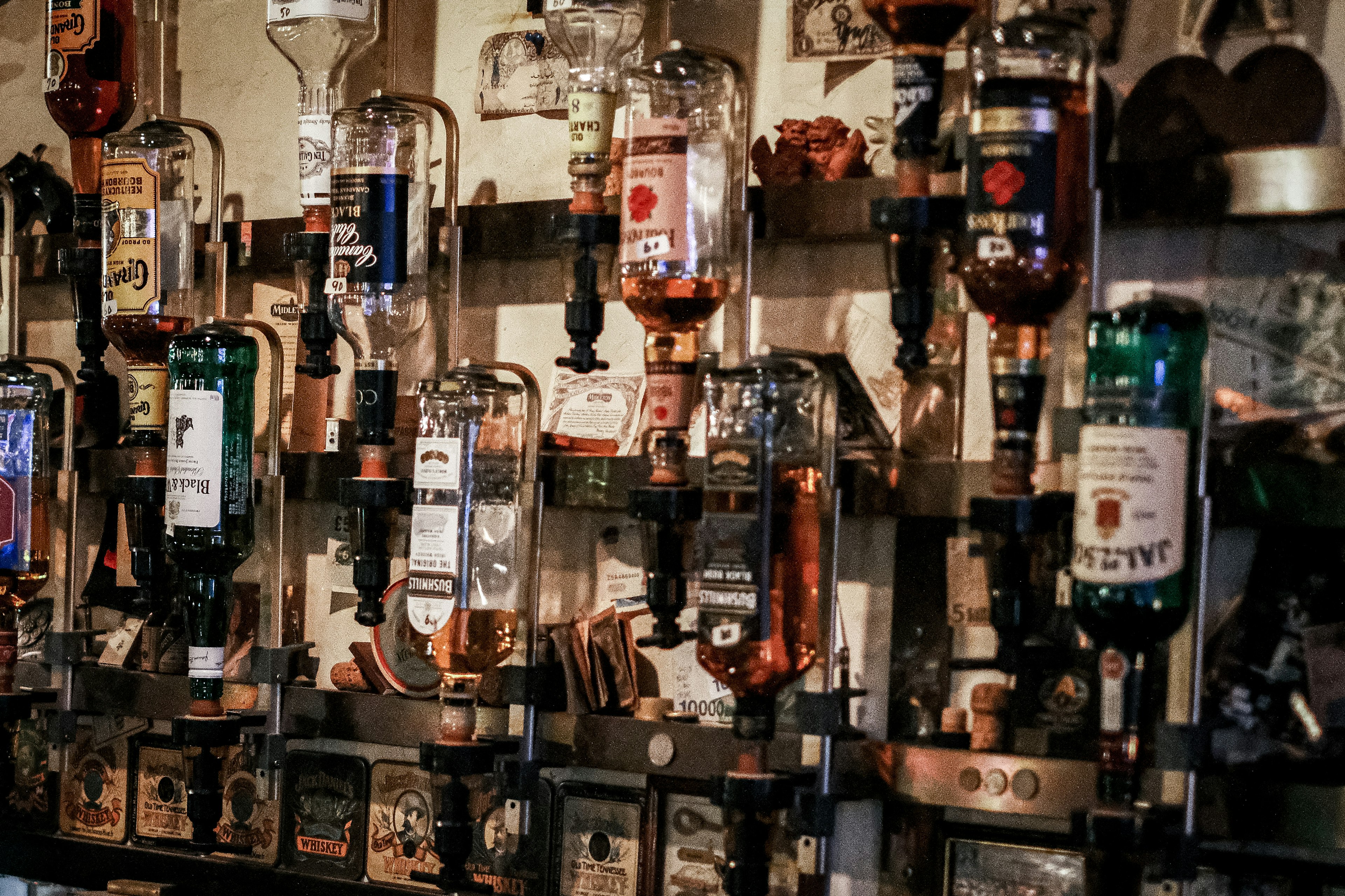 A display of various liquor bottles arranged on a bar wall