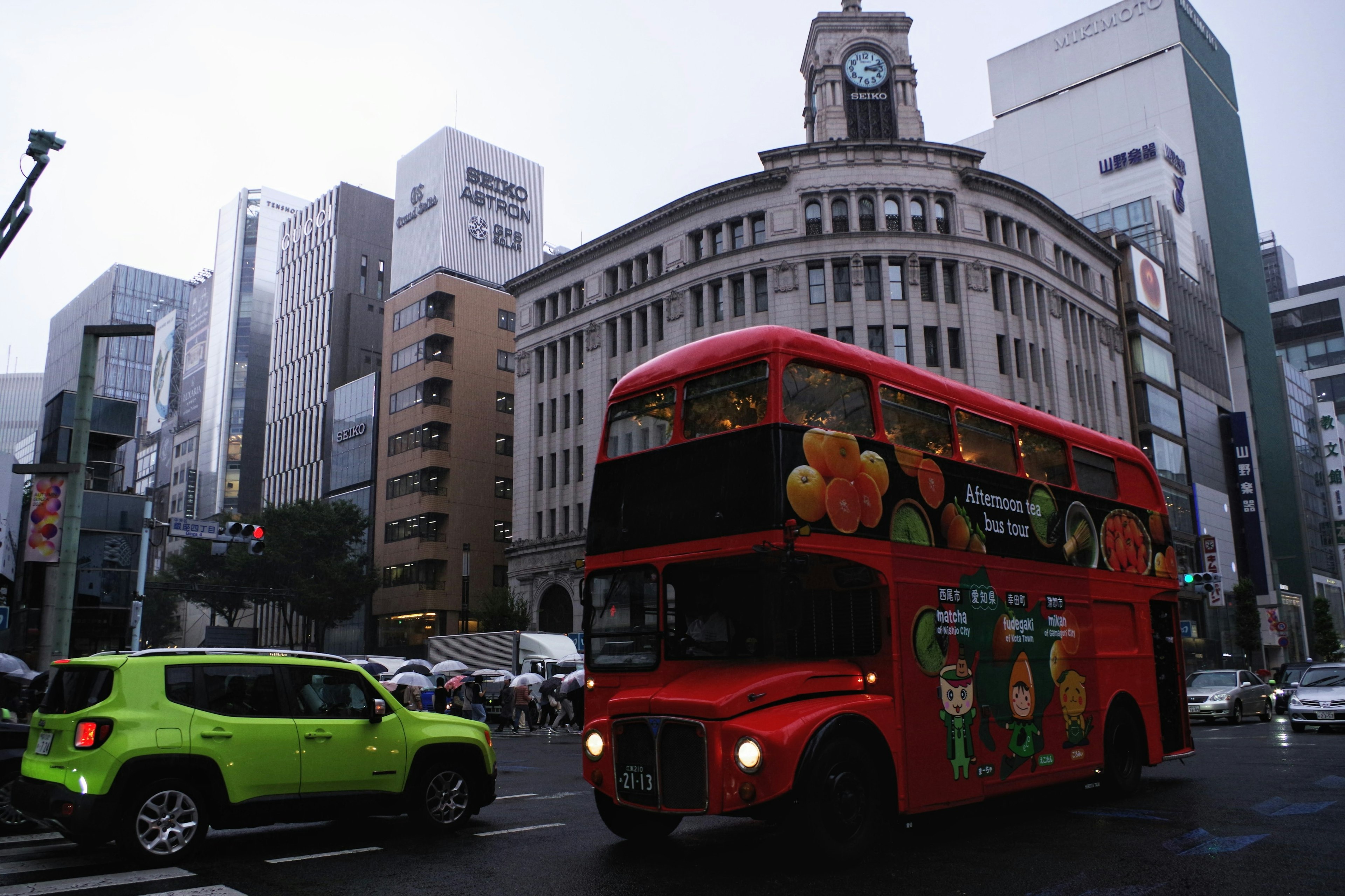 赤い二階建てバスが銀座の街を走る風景