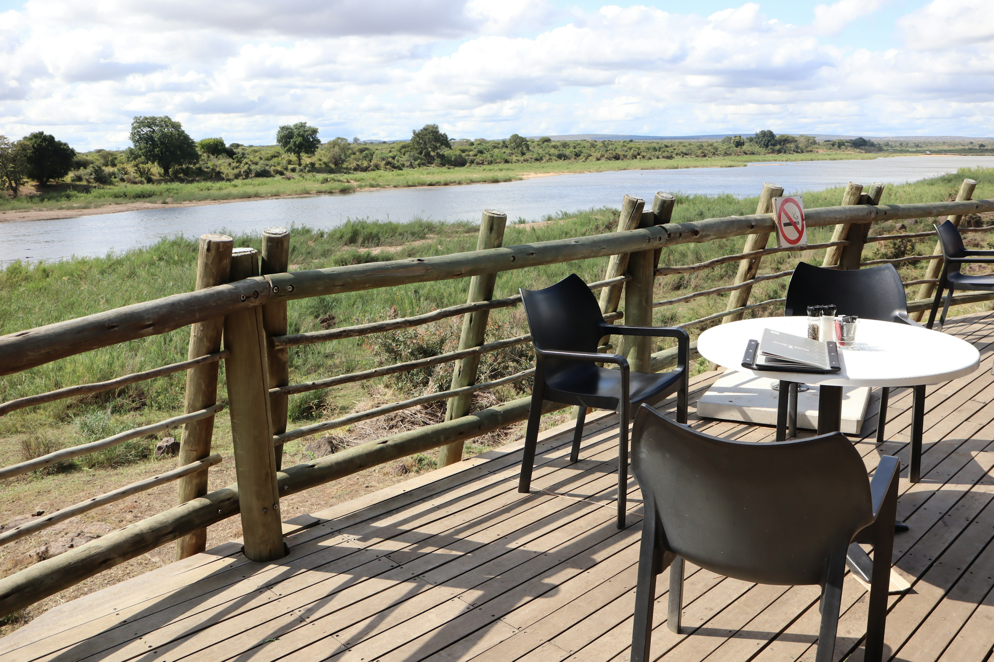 Outdoor terrace with chairs and a table overlooking a river