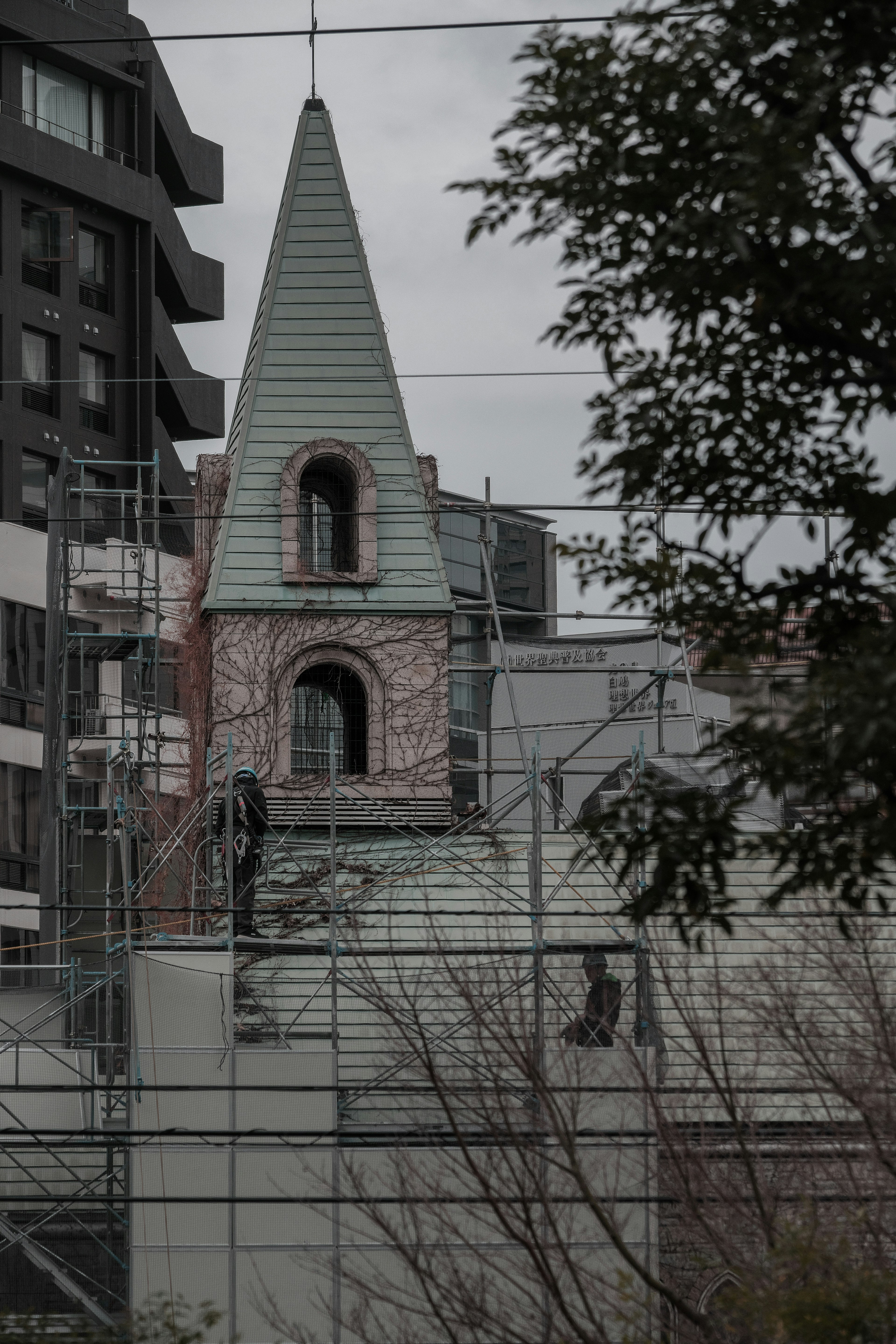 Une partie d'une église avec un clocher et des murs en briques est visible