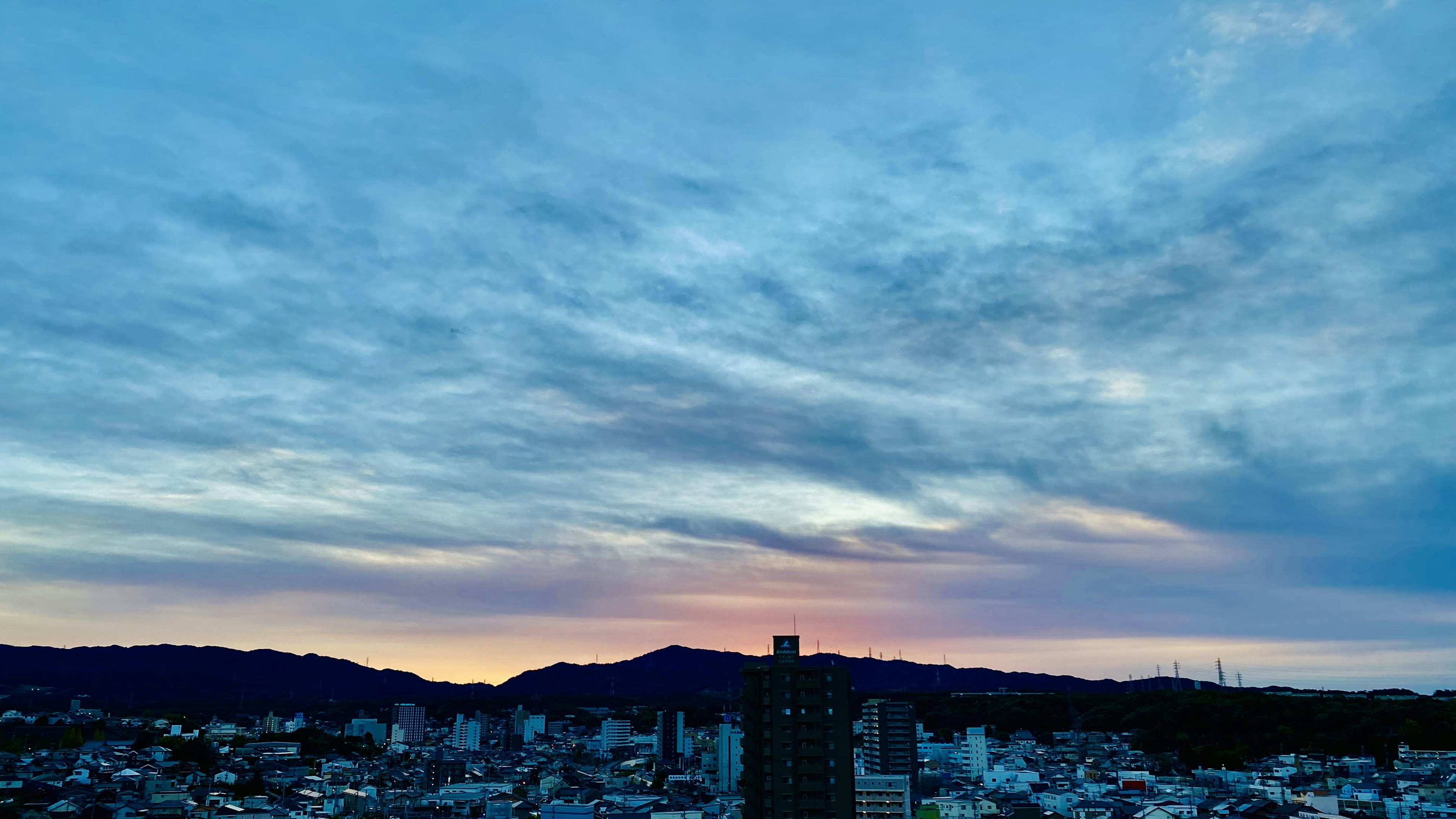 Skyline de la ville au coucher du soleil avec des couleurs vives et des nuages en couches