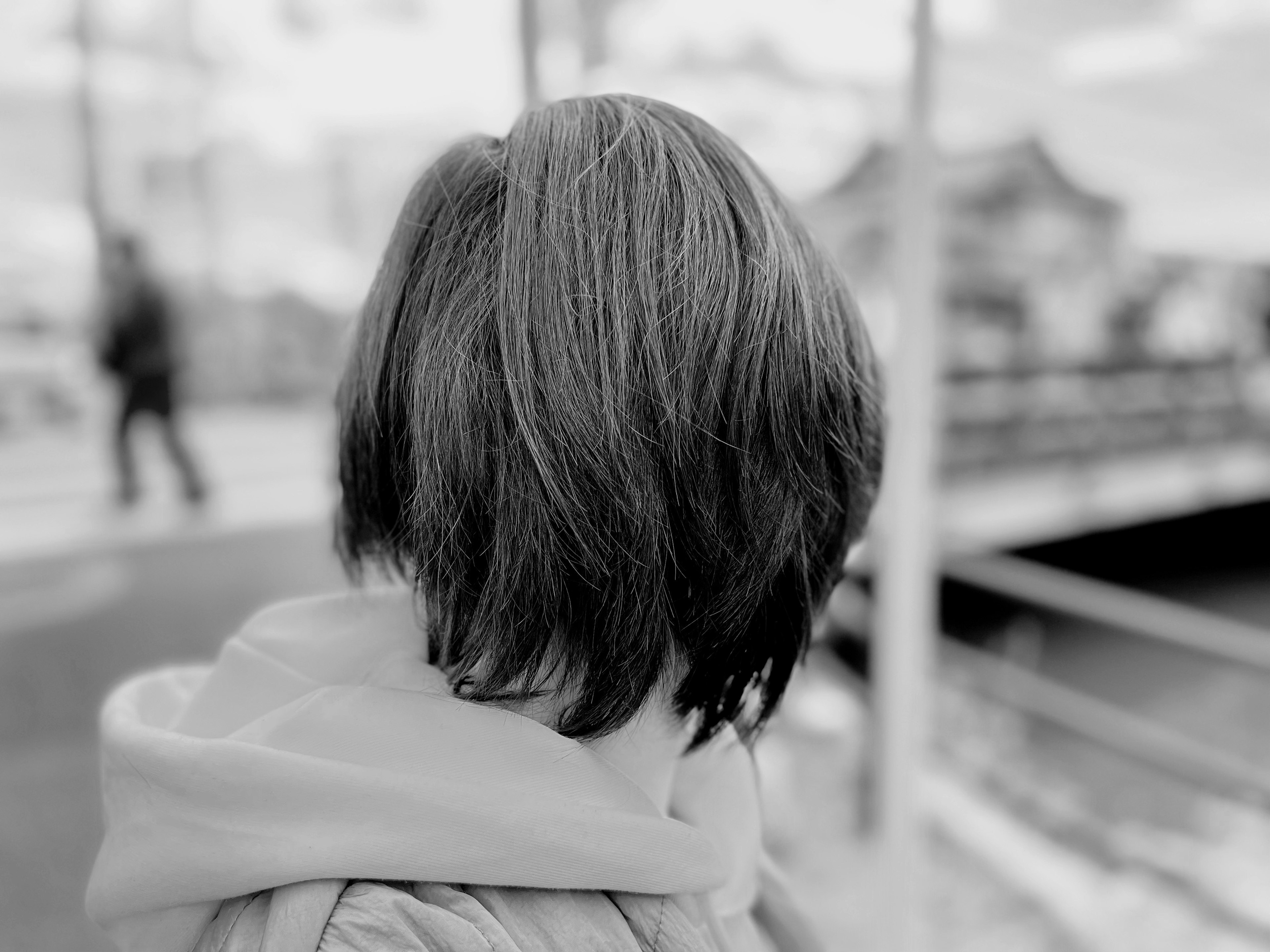 Schwarzweißbild einer Frau von hinten, die in der Stadt läuft