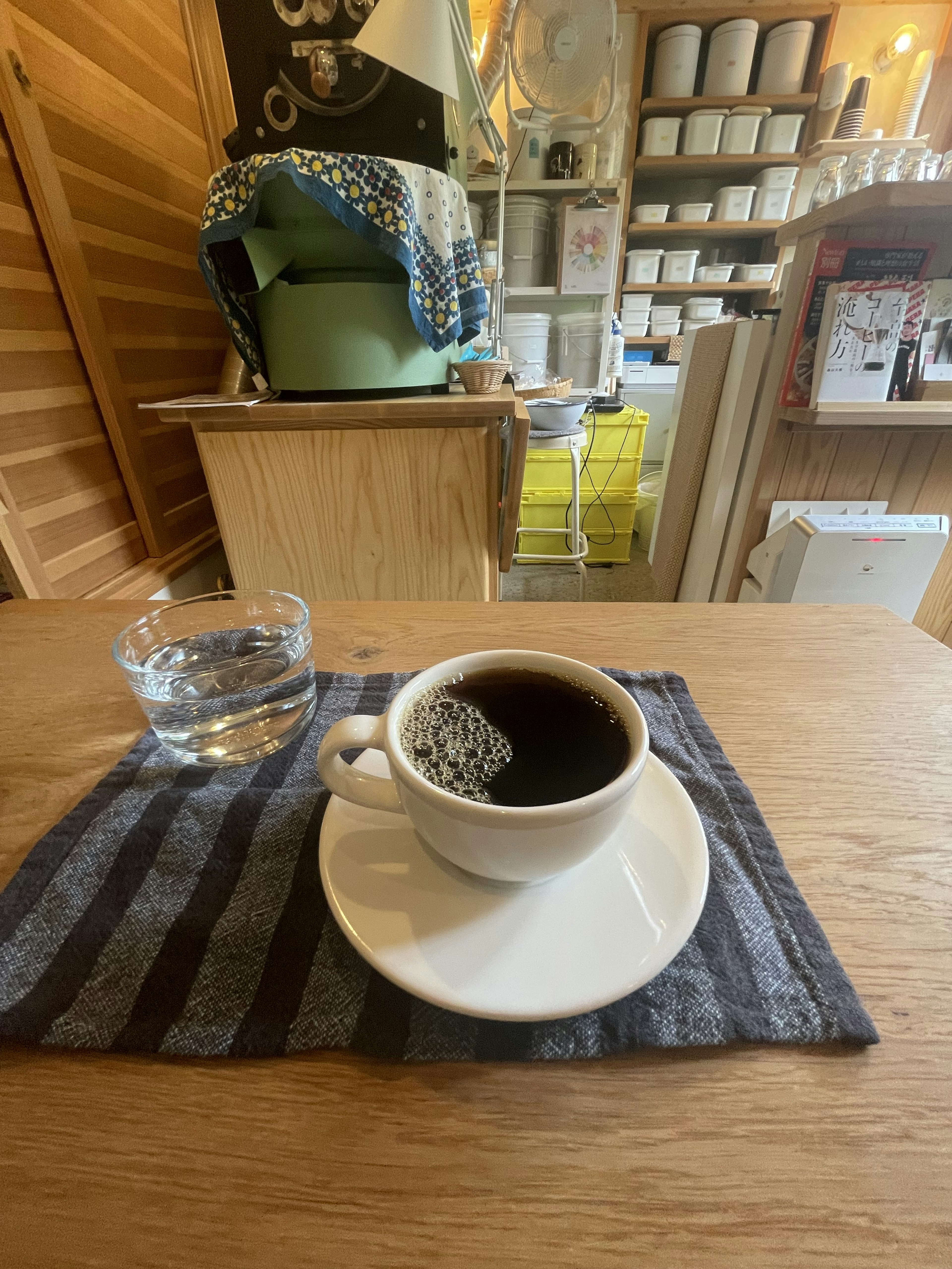 Una scena di caffè semplice con una tazza di caffè e un bicchiere d'acqua su un tavolo di legno