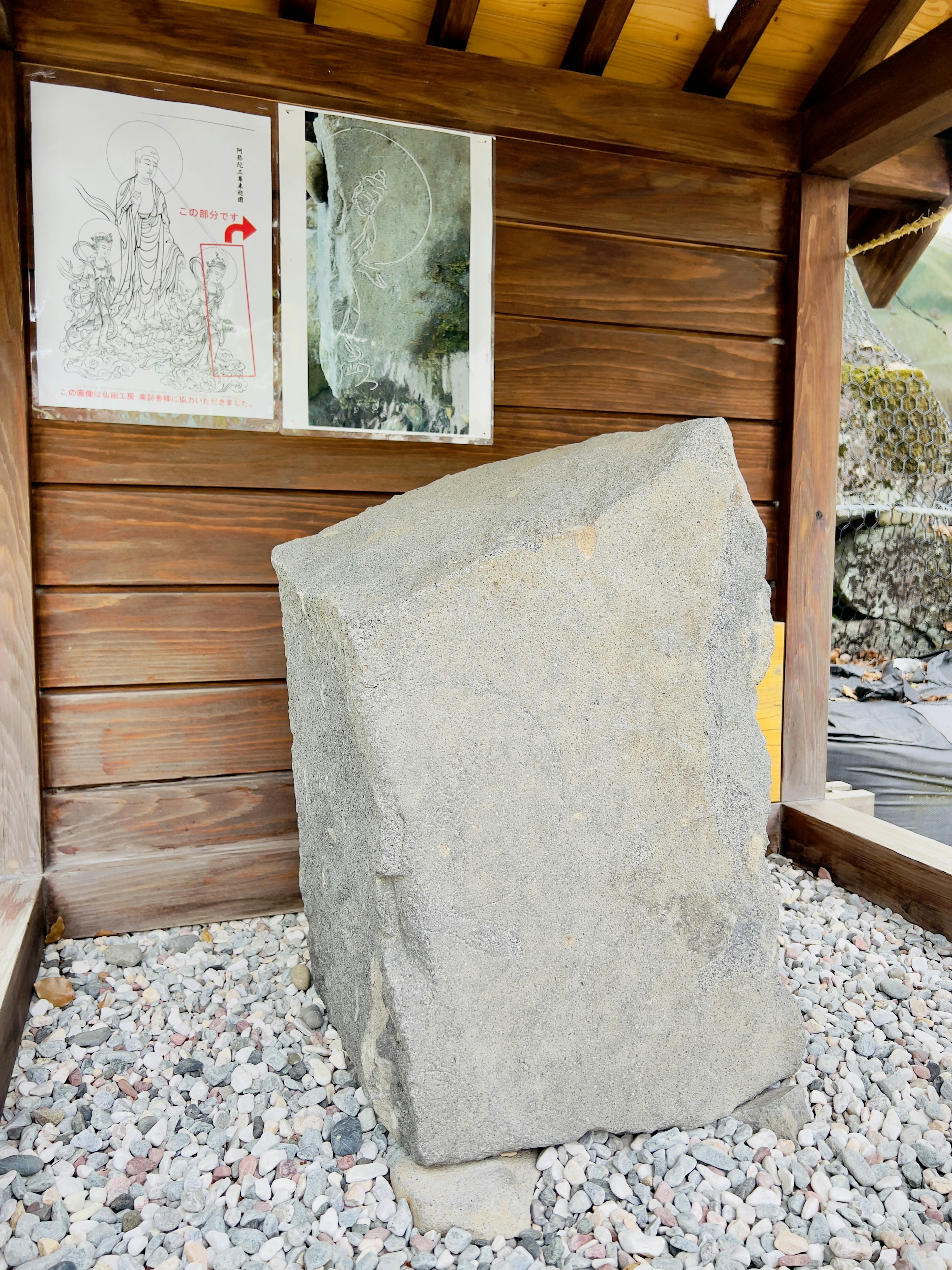 Pierre carrée dans un abri en bois avec des dessins sur le mur