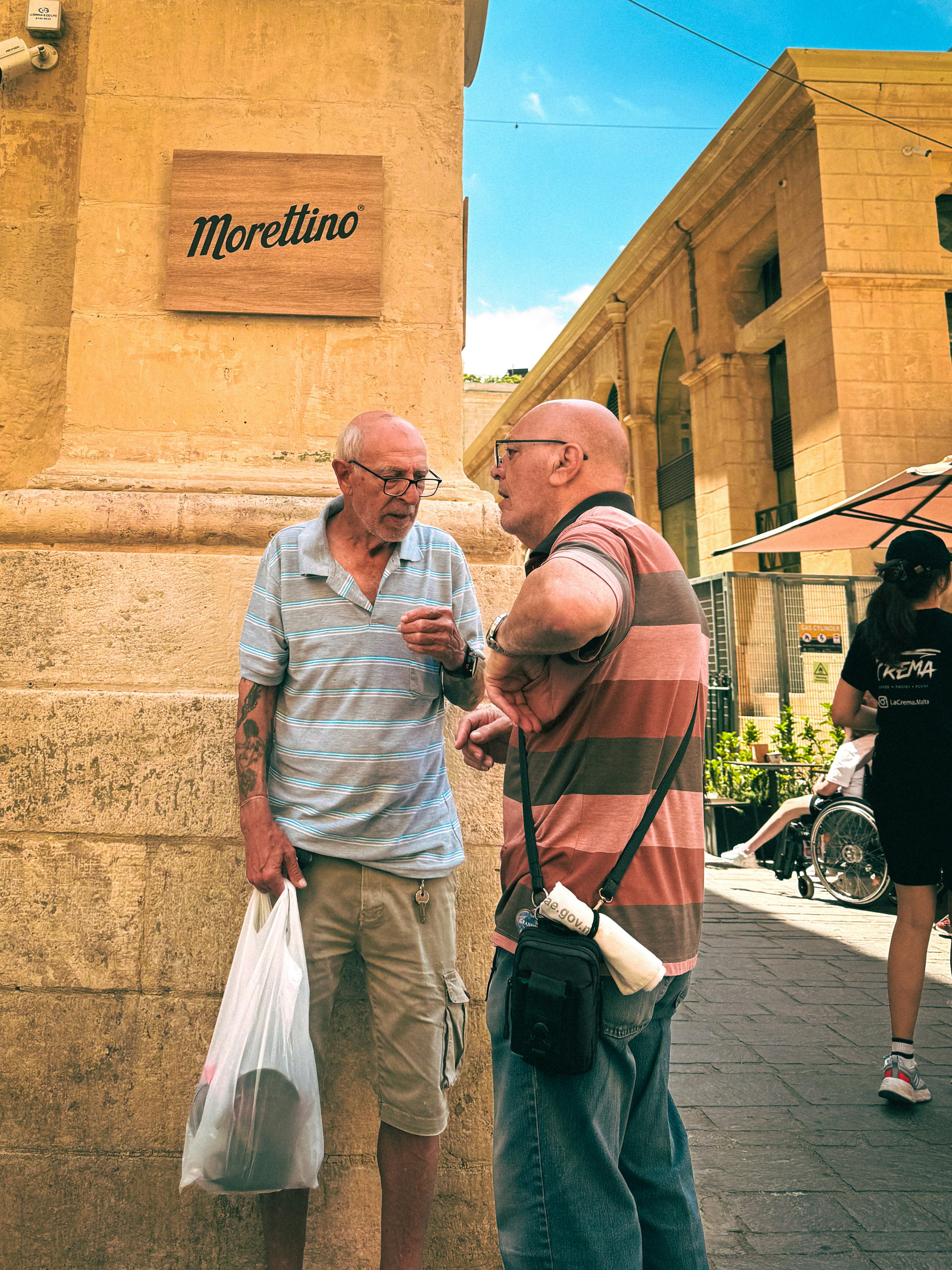 Two men engaged in conversation on a street corner