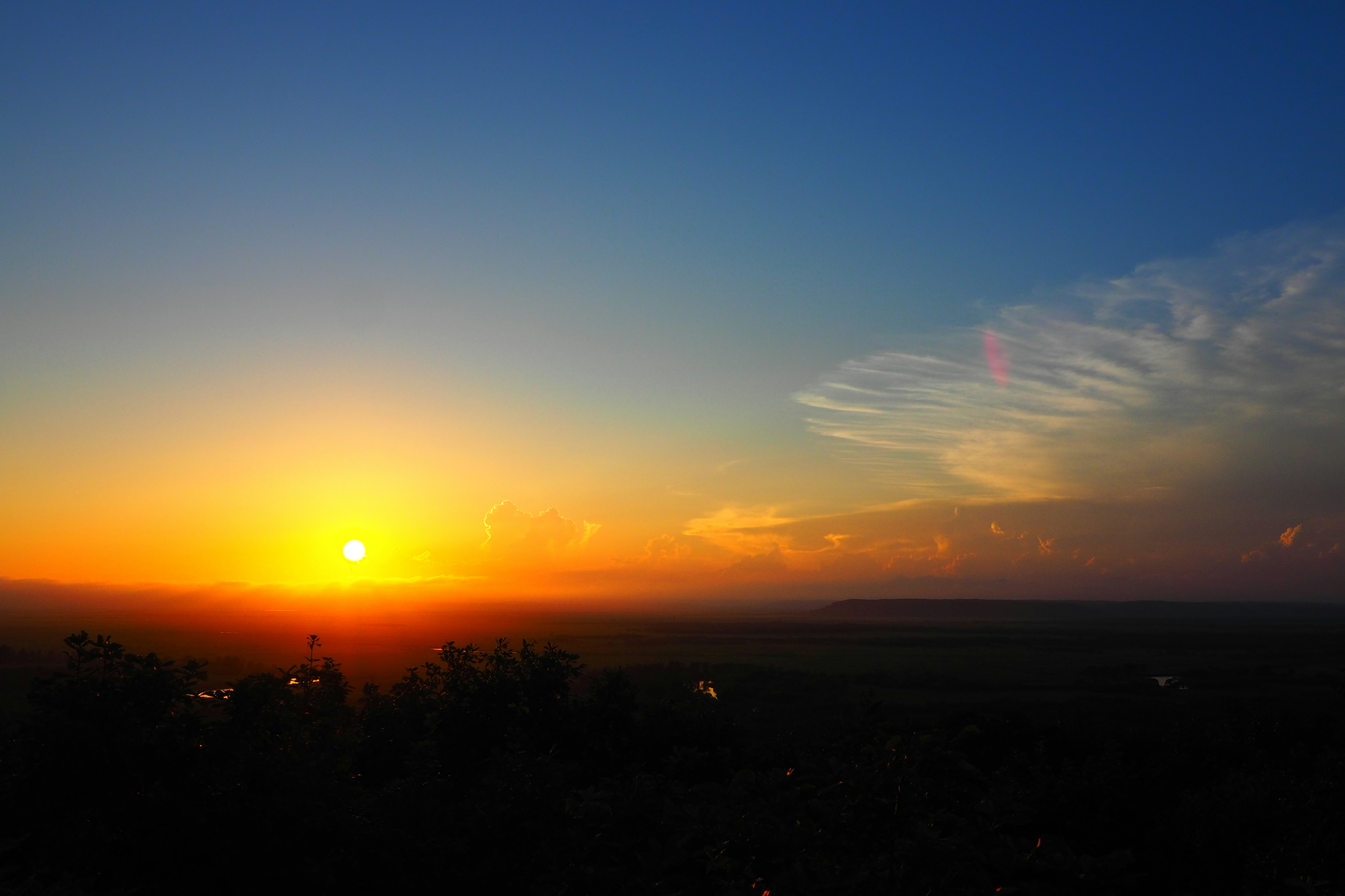 Magnifique coucher de soleil à l'horizon avec un ciel bleu et des nuages oranges