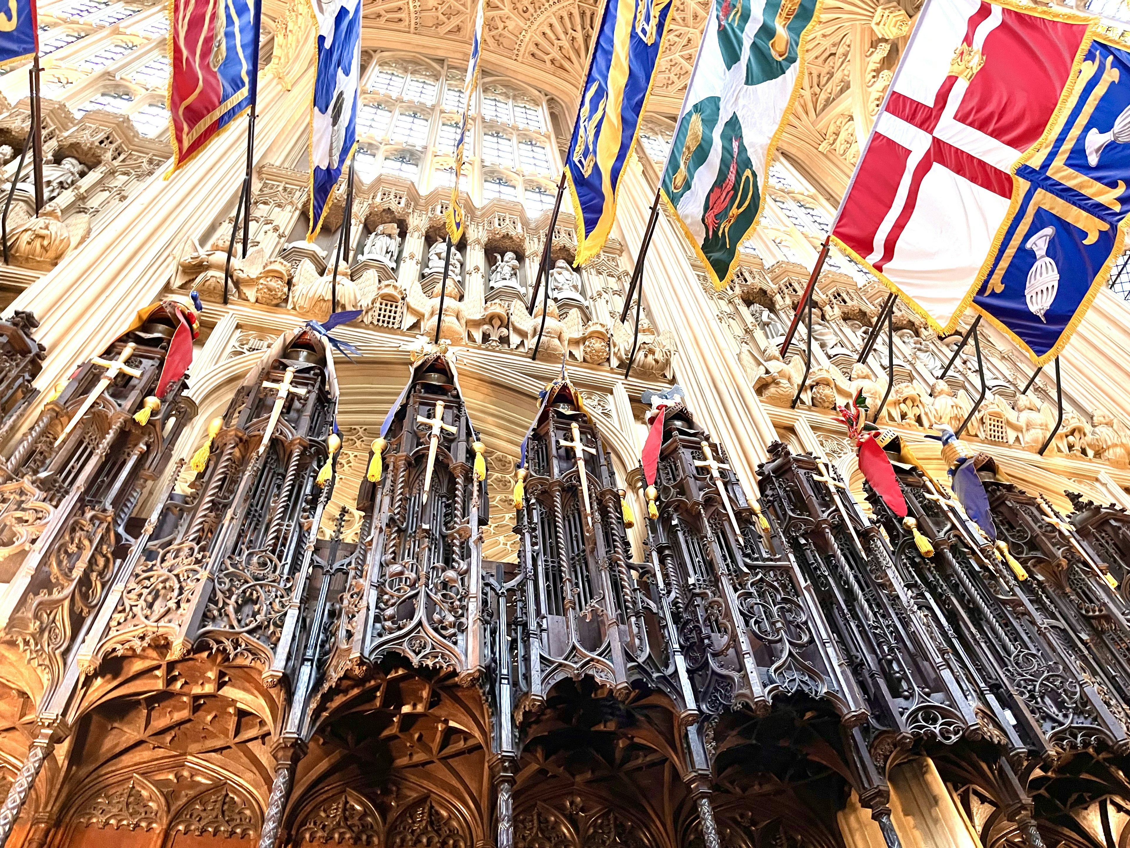 Vista interior de una catedral con decoraciones intrincadas y banderas coloridas