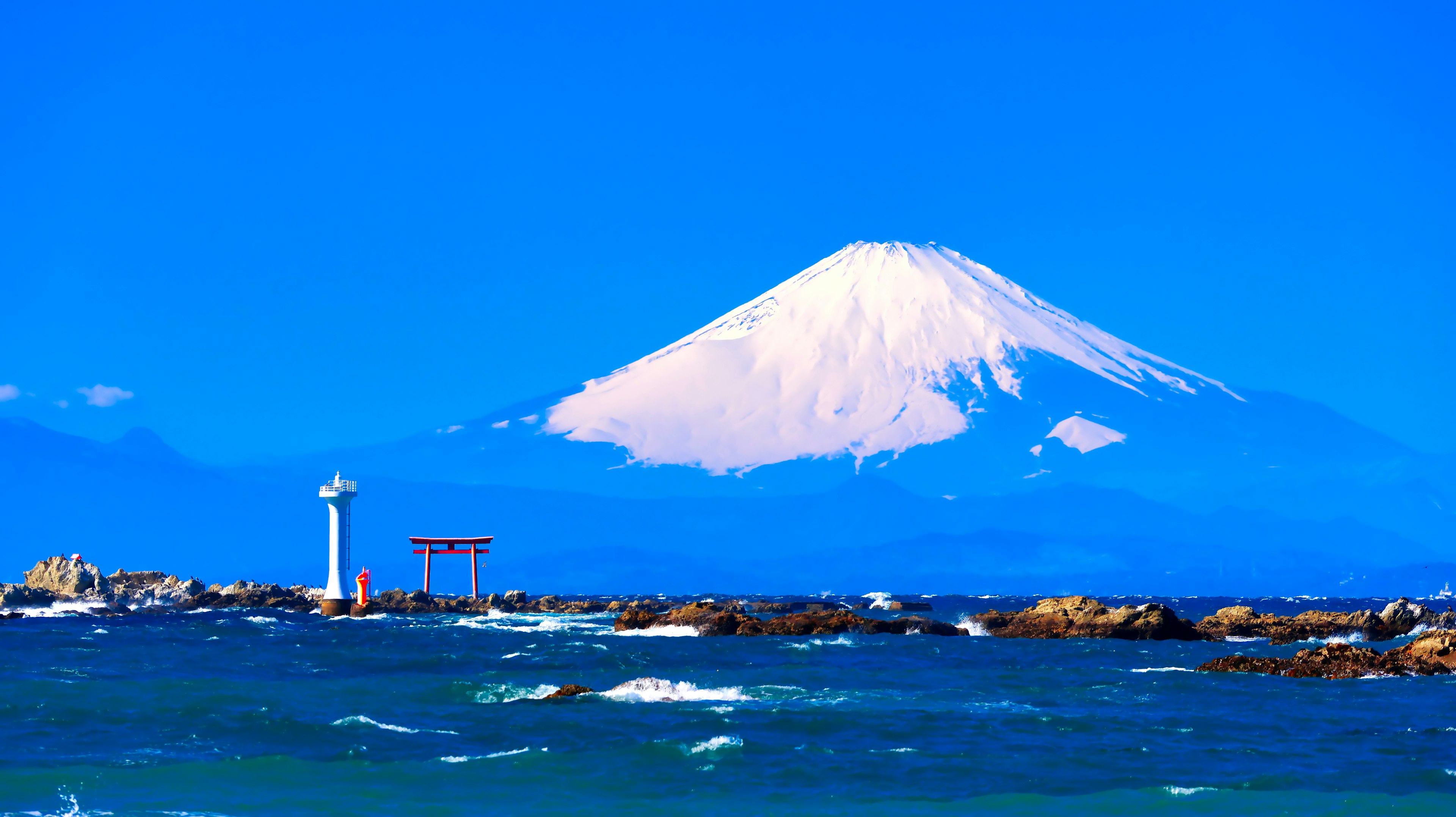 Malersicher Blick auf den Fuji vor einem strahlend blauen Himmel mit einem Leuchtturm