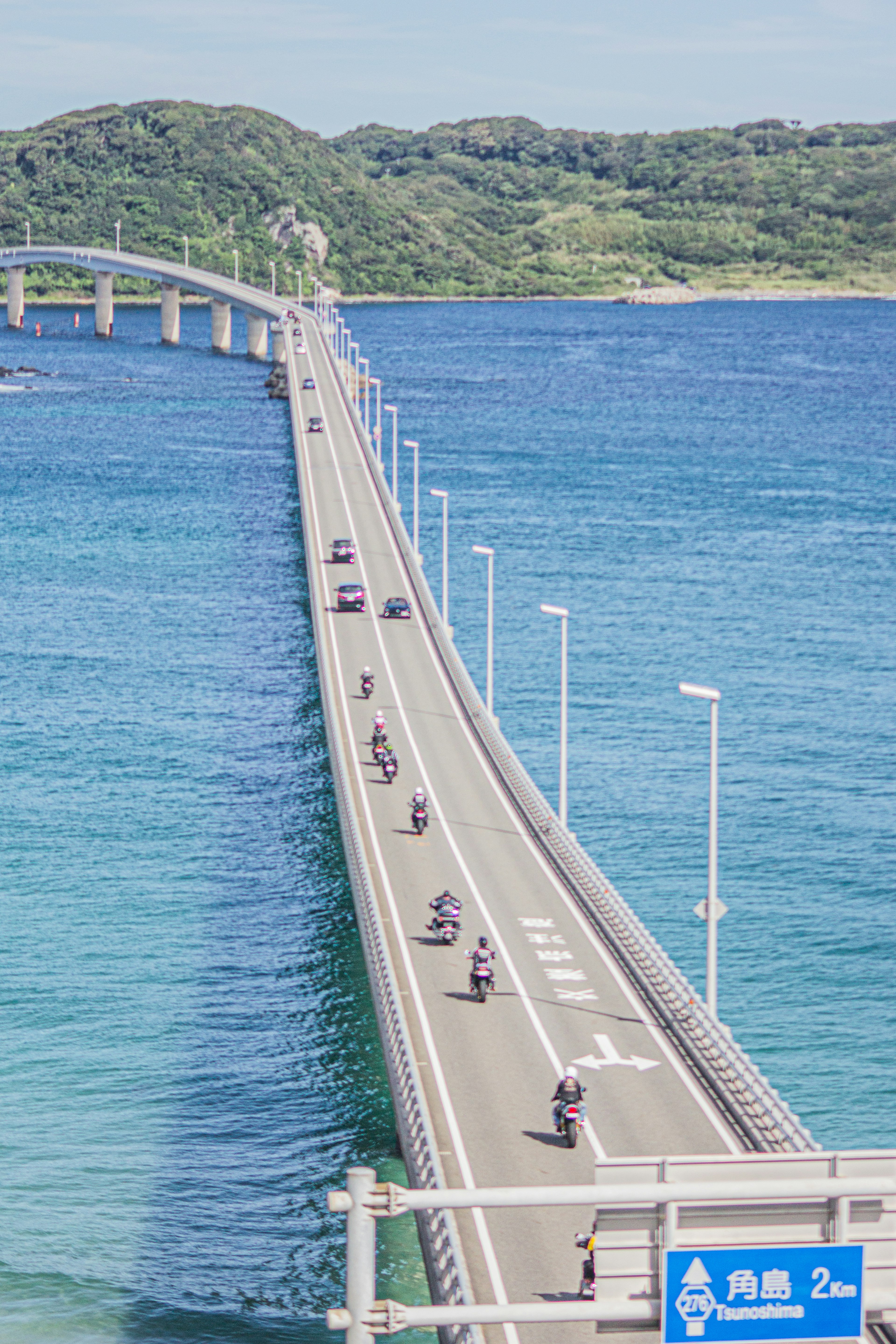 Langer Brücke über blaues Meer mit Motorrädern