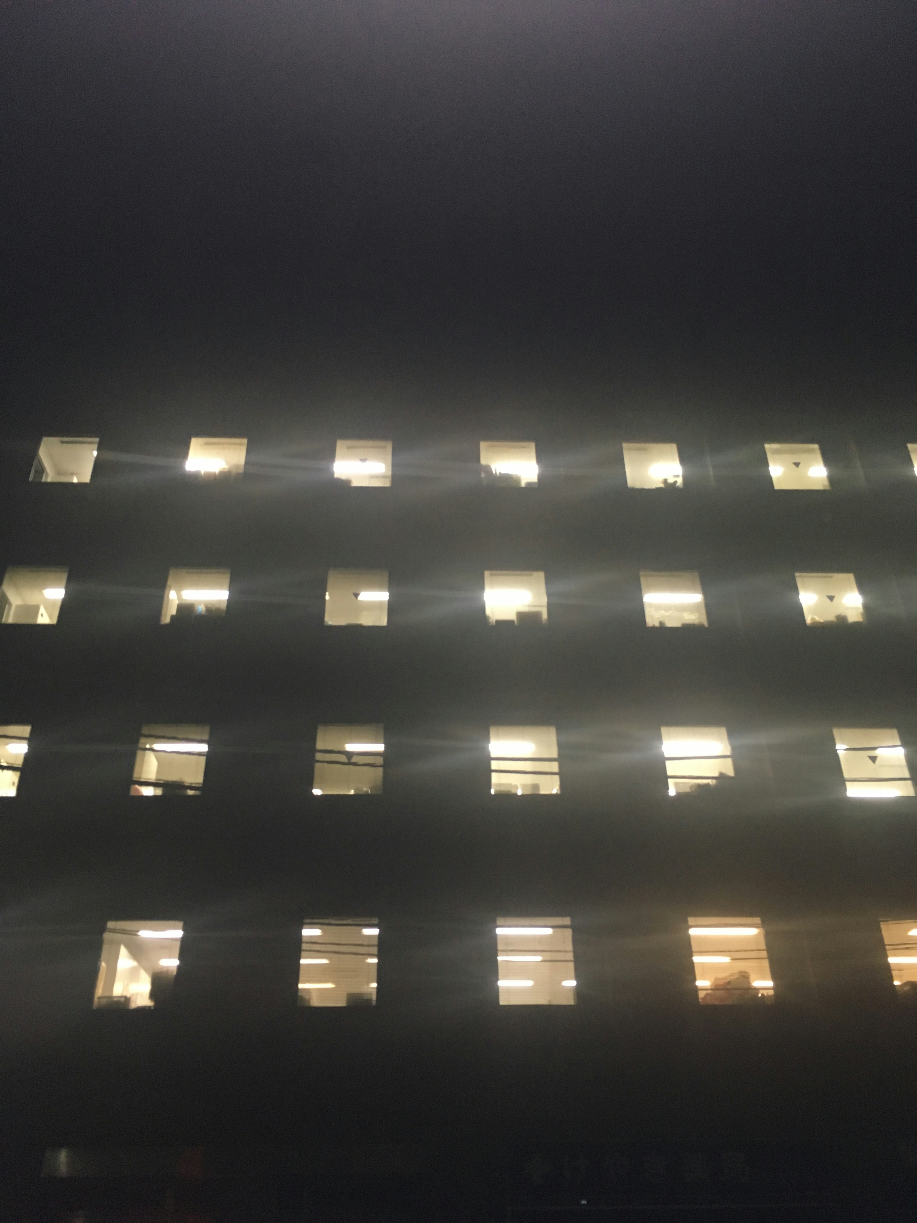 Illuminated windows of a building at night creating a striking facade