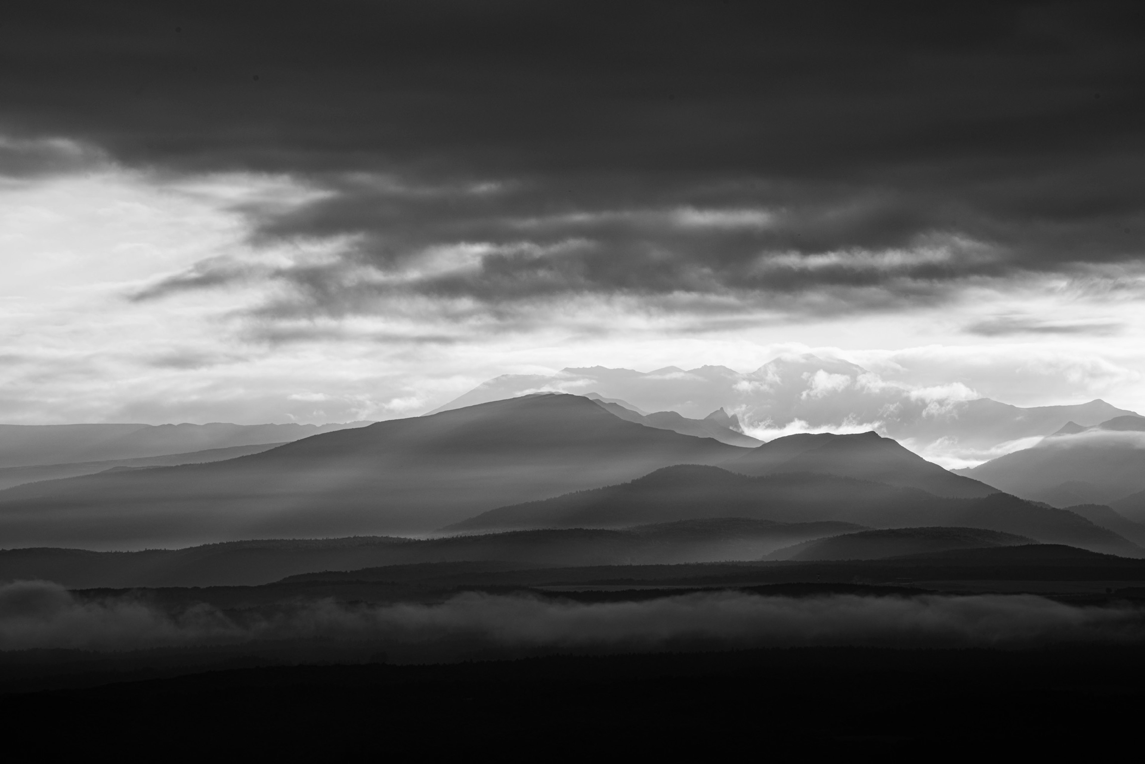 Black and white landscape featuring misty mountains