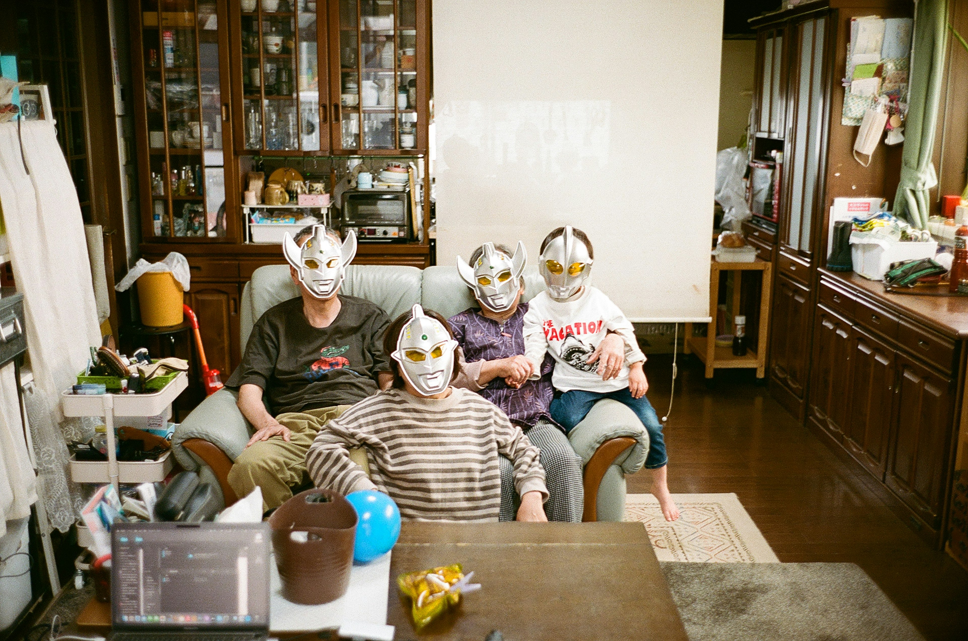 Family members wearing masks sitting in a living room