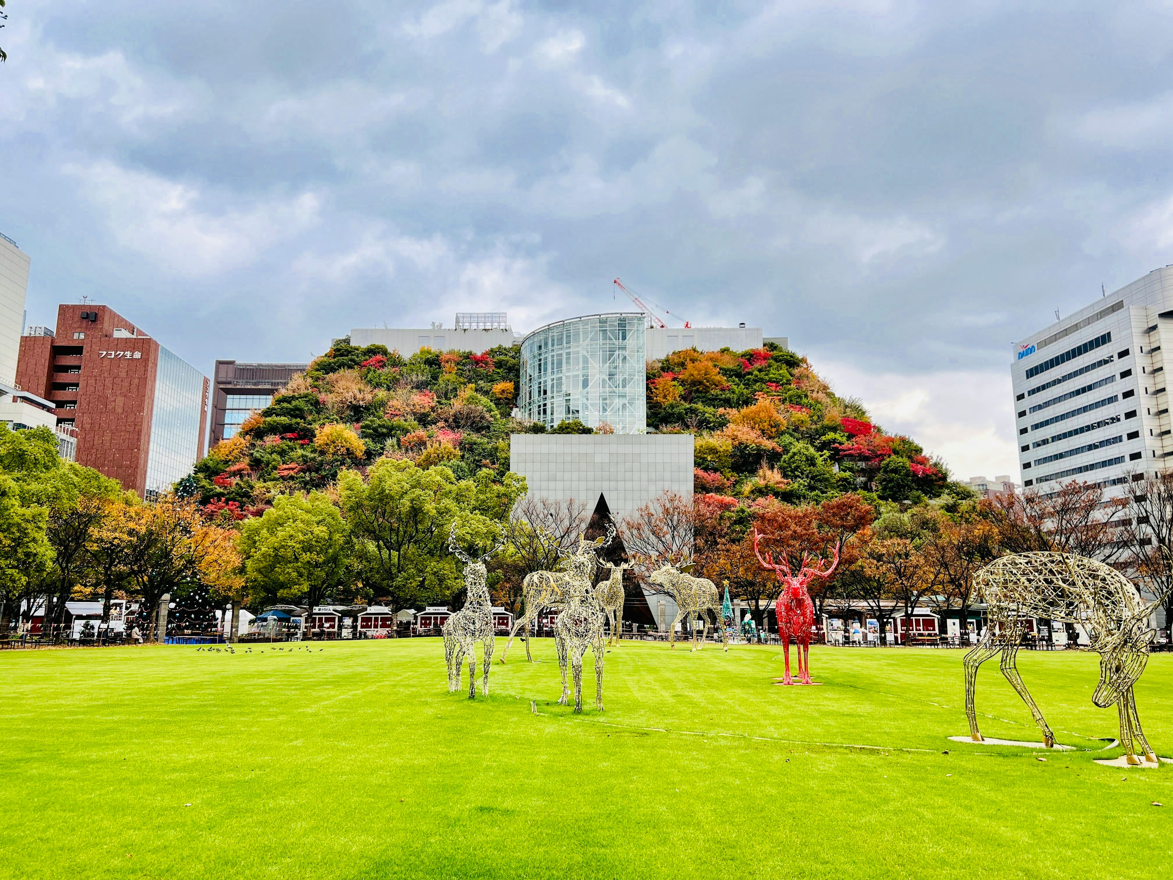 緑の芝生とアートの彫刻がある公園の風景