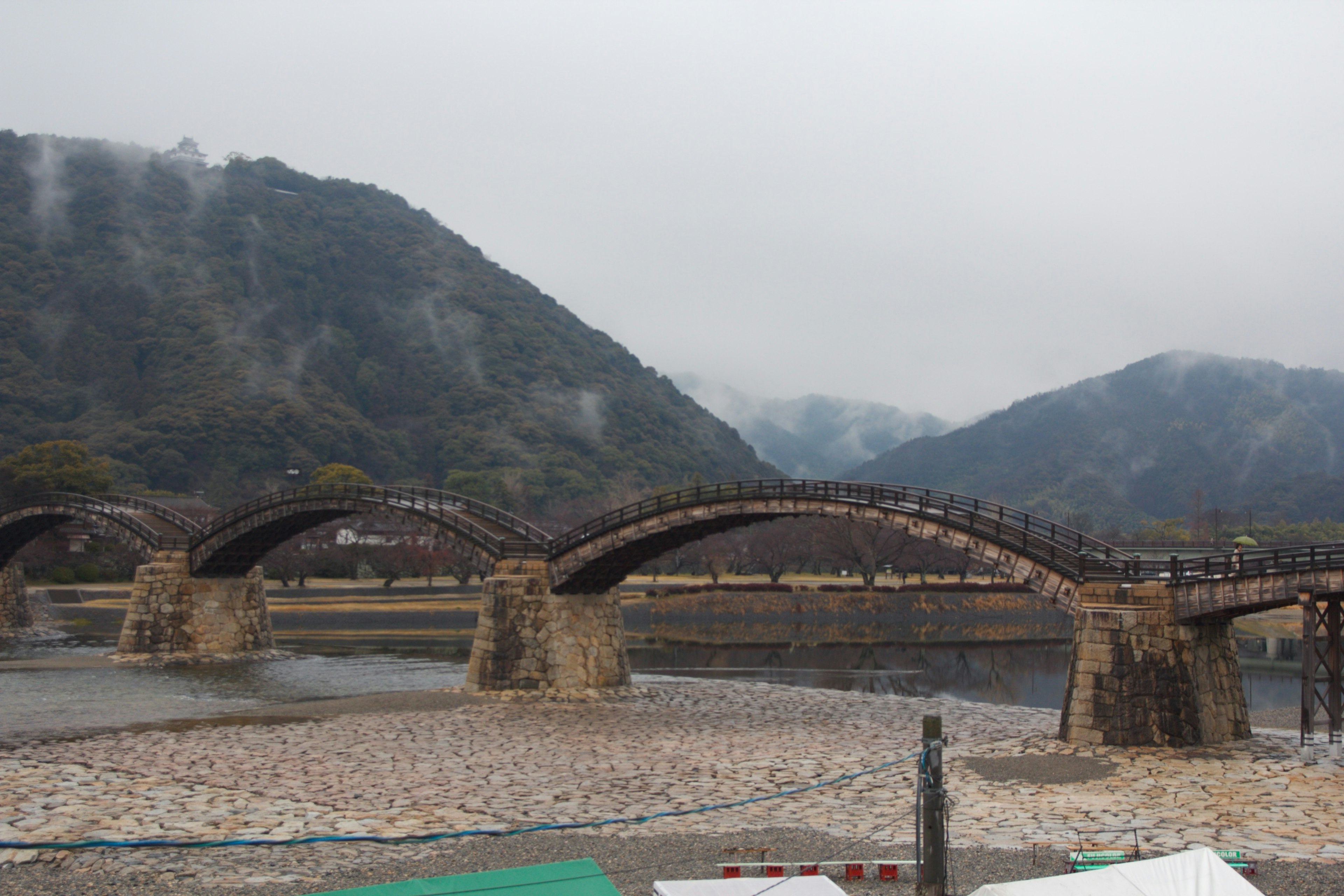 Hermoso puente de arco de madera rodeado de montañas