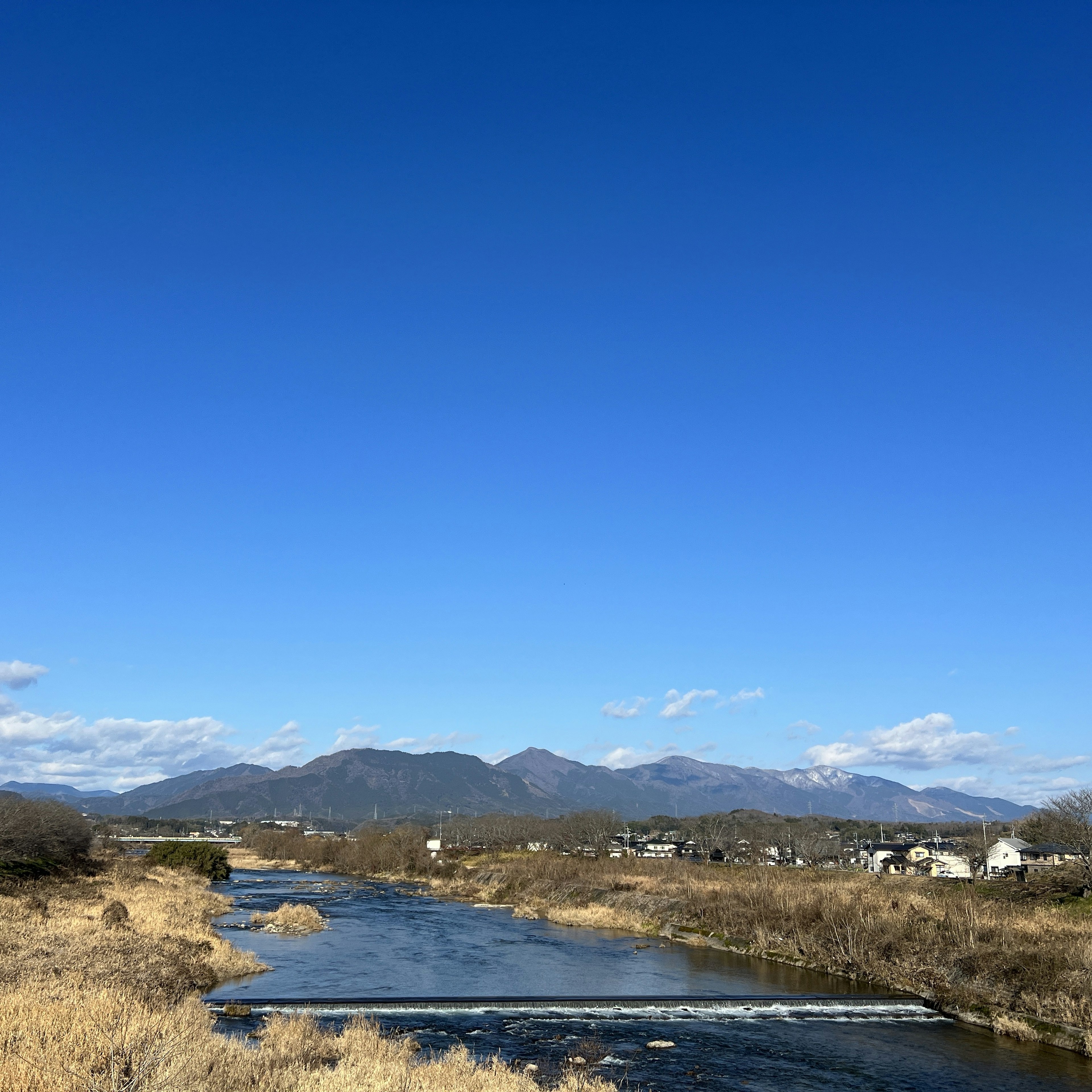 River landscape with a clear blue sky and mountains in the background