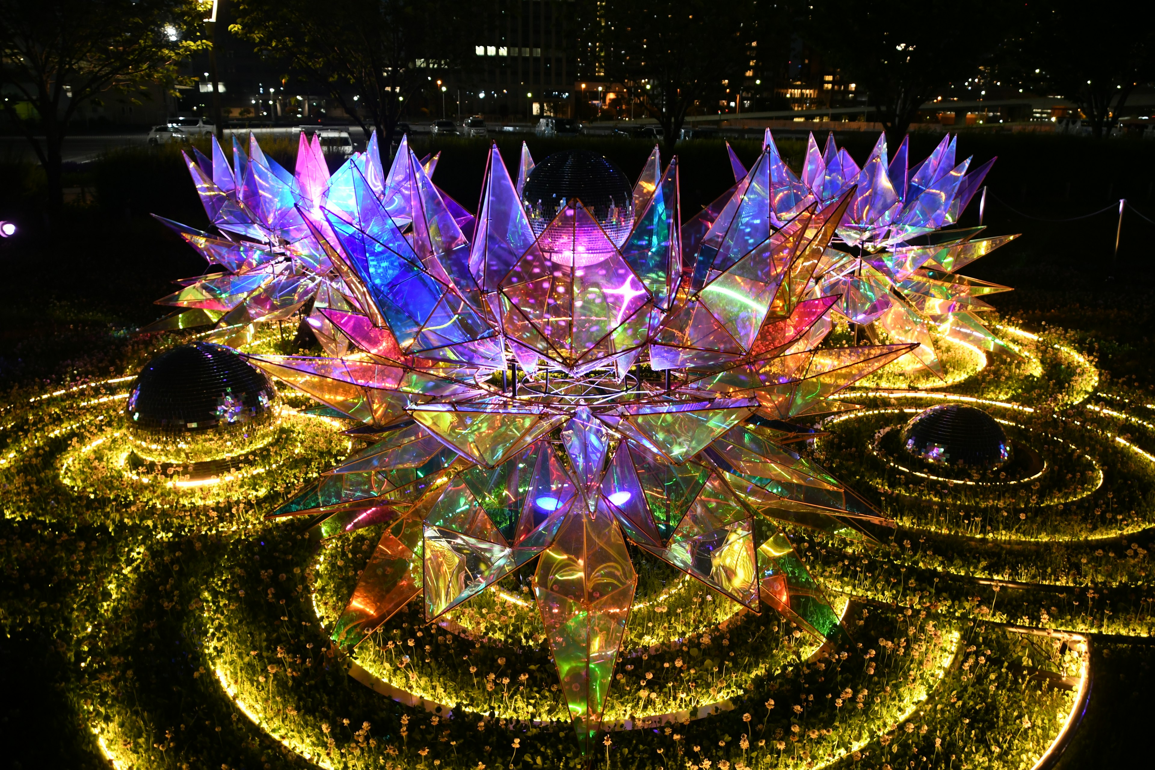 Colorful illuminated floral art installation at night