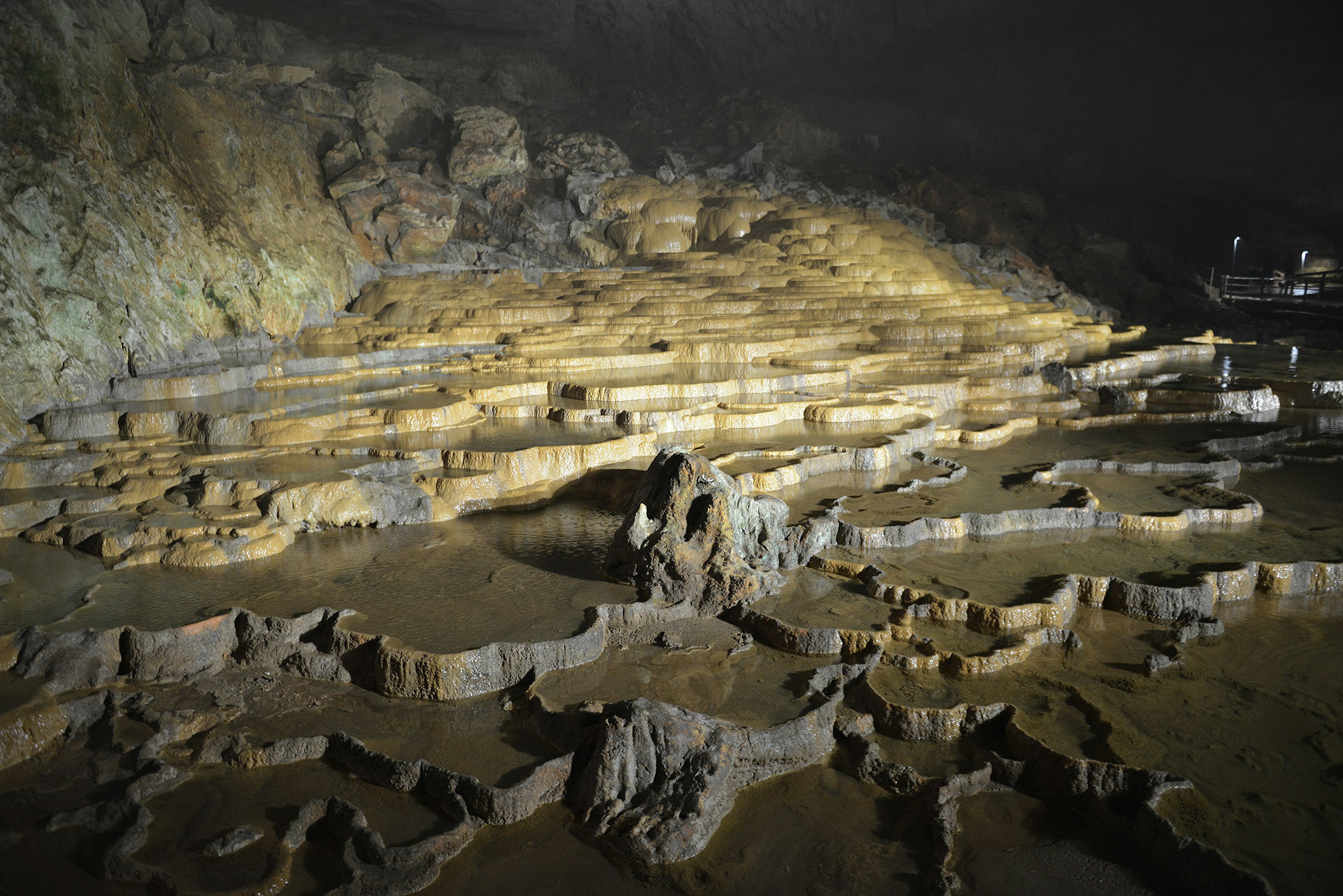 Formaciones rocosas en terrazas naturales dentro de una cueva oscura