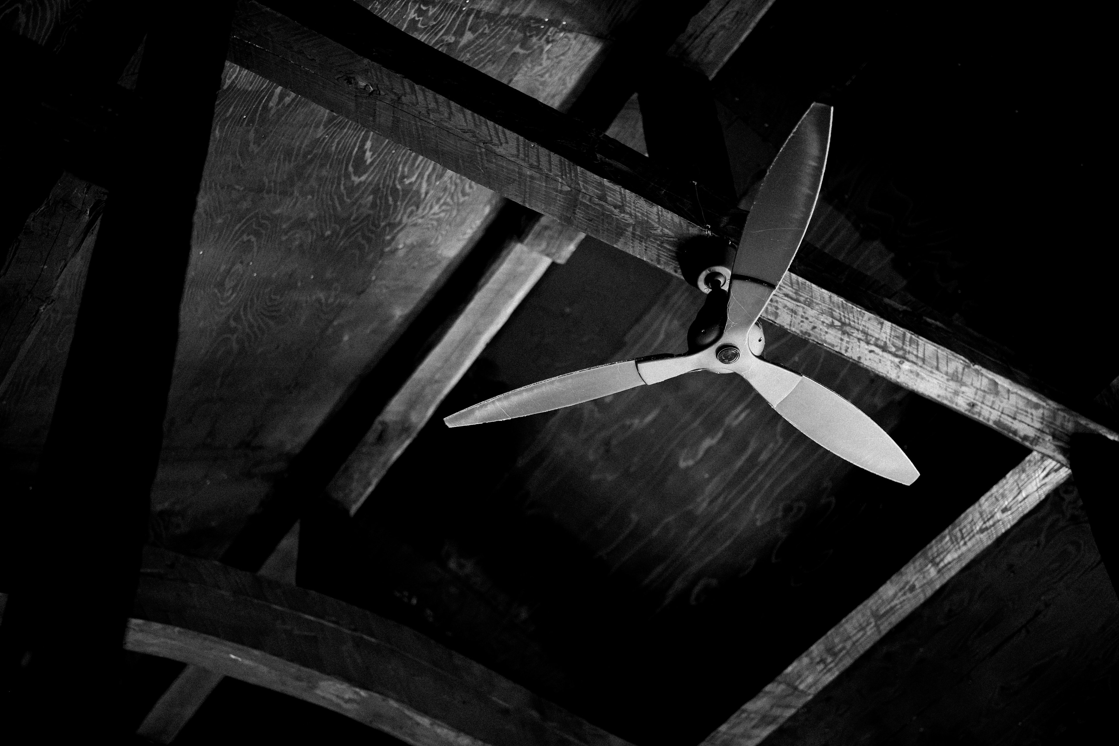 Image d'un ventilateur de plafond blanc sur fond sombre