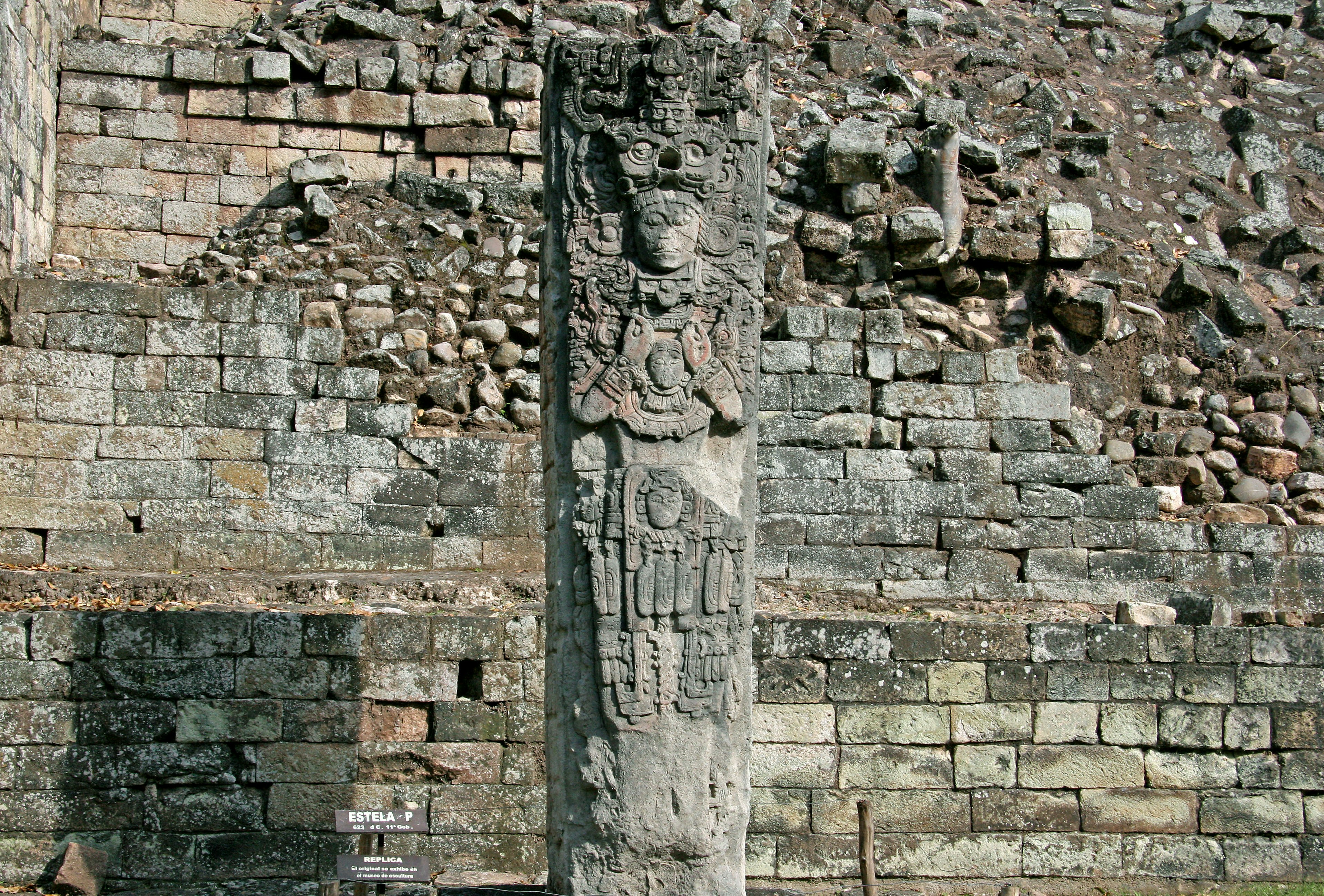 Estatua de piedra antigua contra una pared desgastada