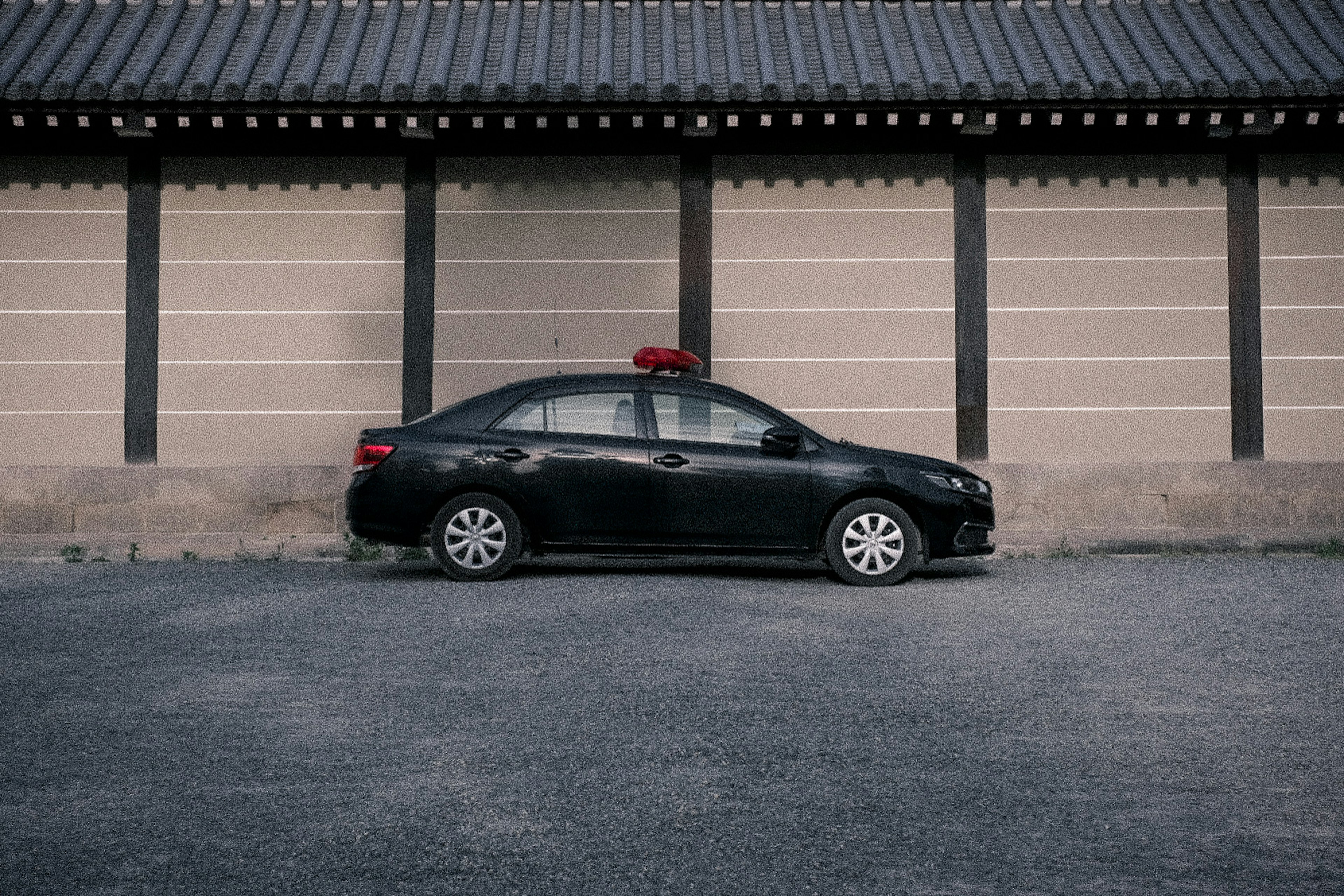 Schwarzes Taxi vor einem traditionellen koreanischen Gebäude geparkt