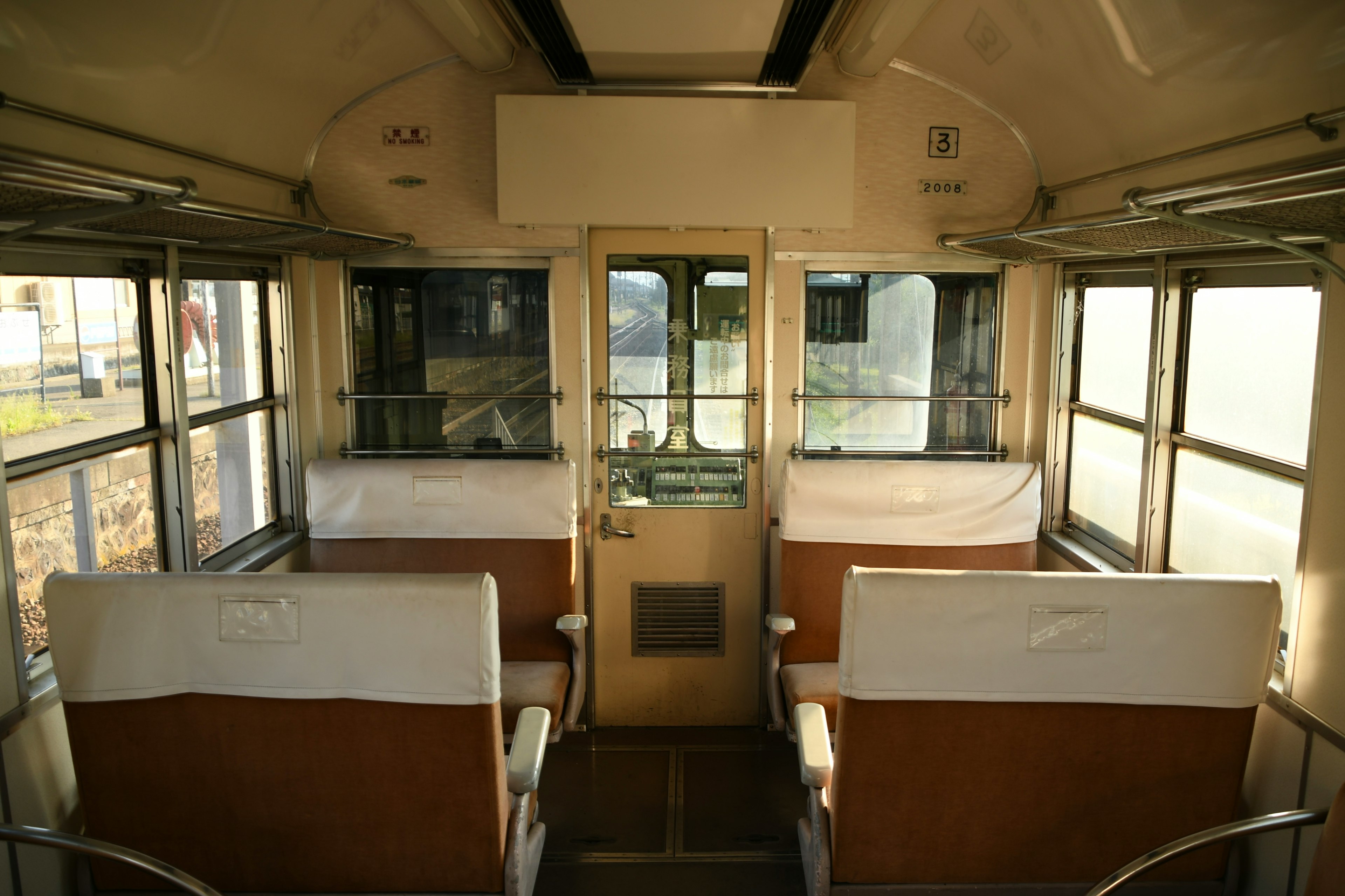 Interno di un vecchio vagone ferroviario con sedili e finestre