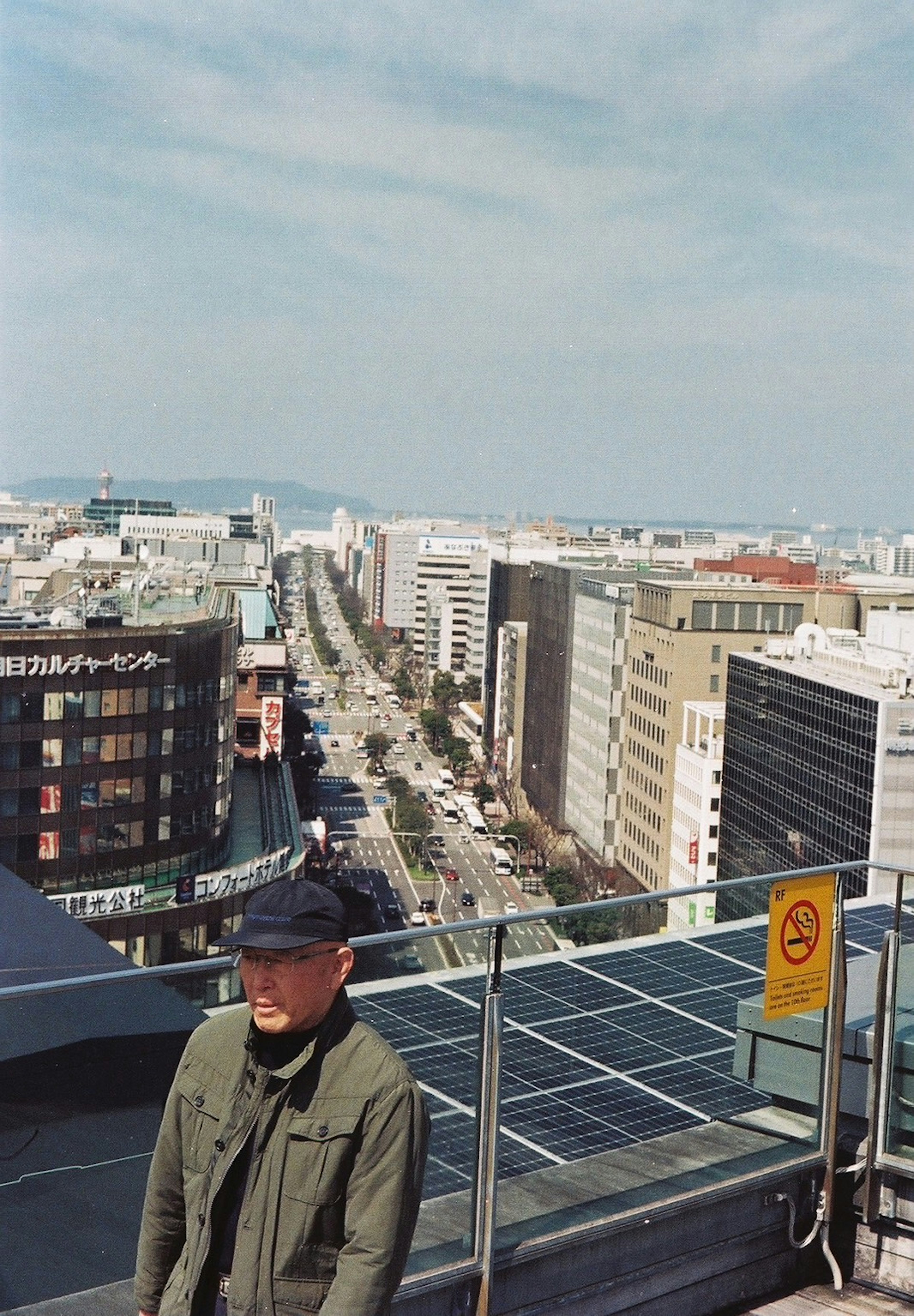 Man standing on a rooftop with a city skyline