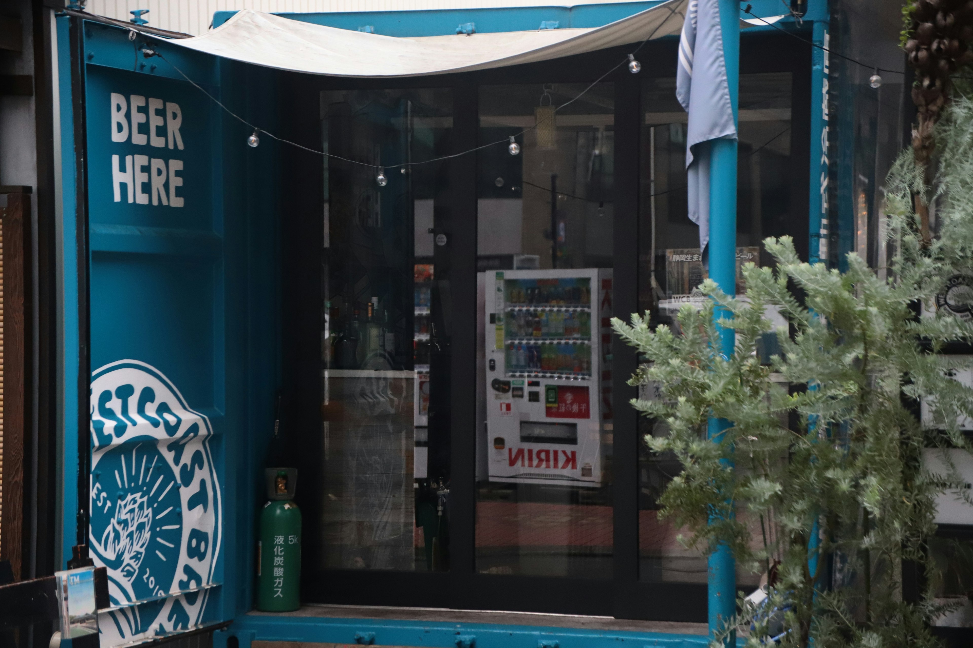 Entrée d'une cabane bleue avec un panneau de bière