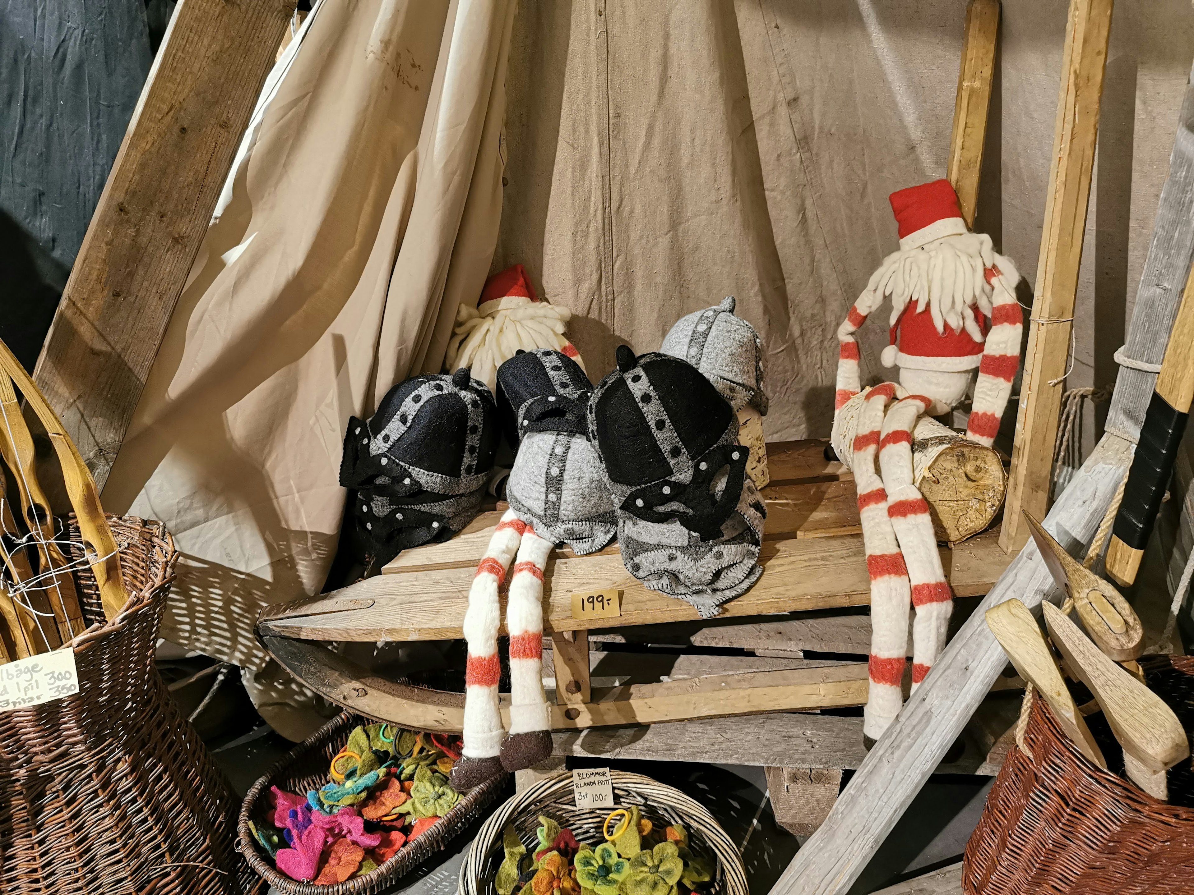 Striped dolls and black-clad dolls sitting on a wooden boat