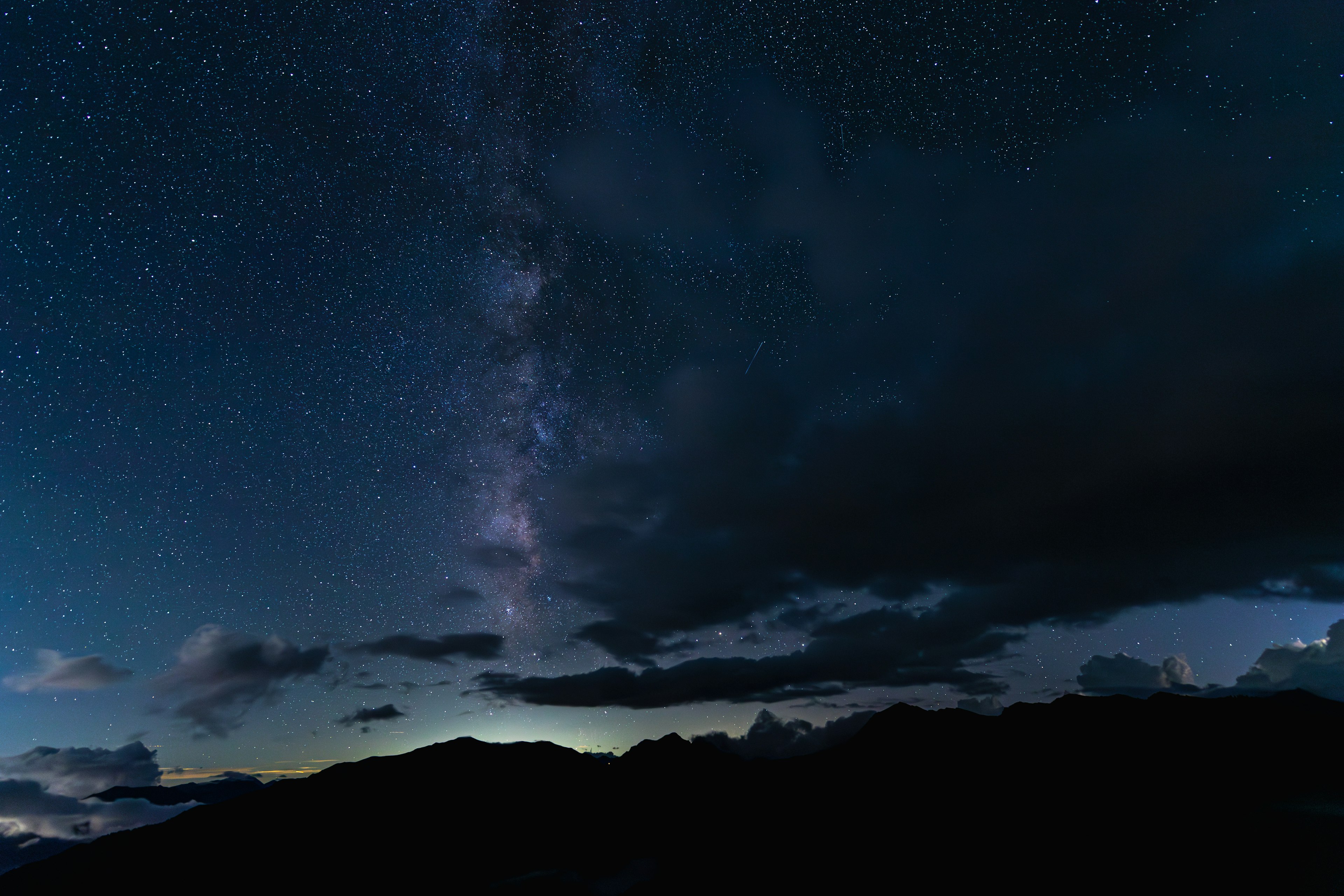 Cielo estrellado con la Vía Láctea y nubes visibles