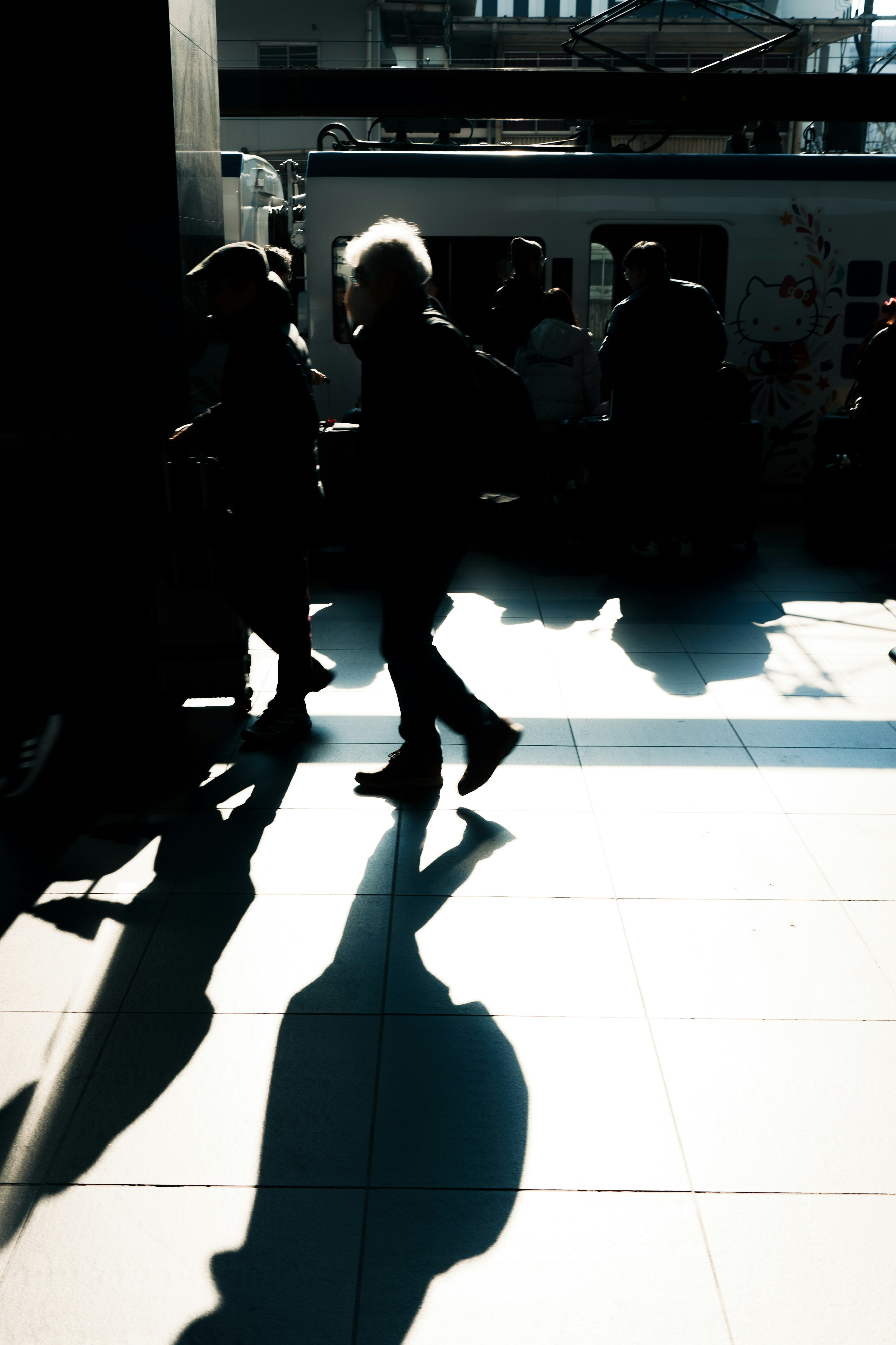 Silhouette of people walking with prominent shadows