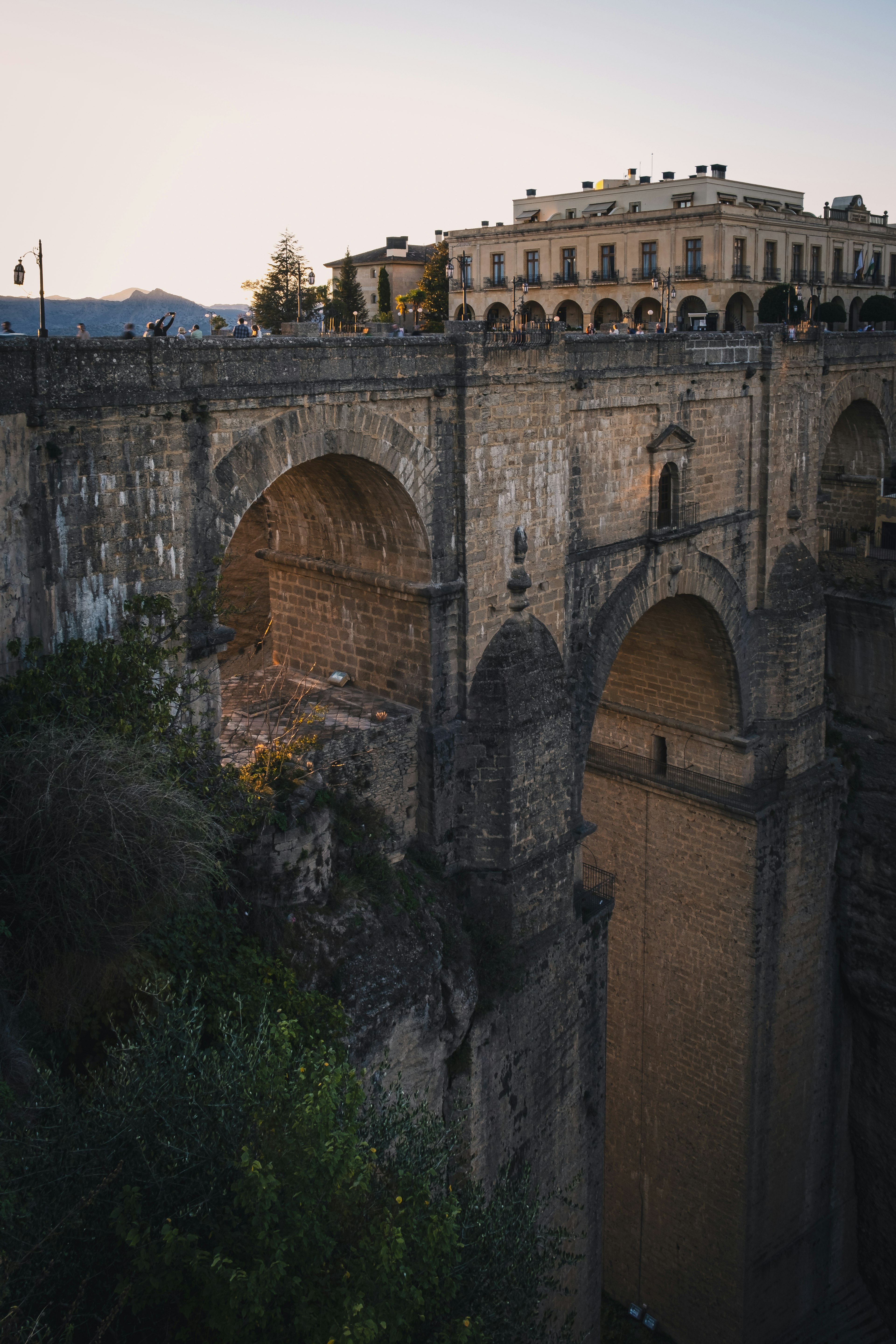 Puente de piedra antiguo con edificios circundantes iluminados por el atardecer